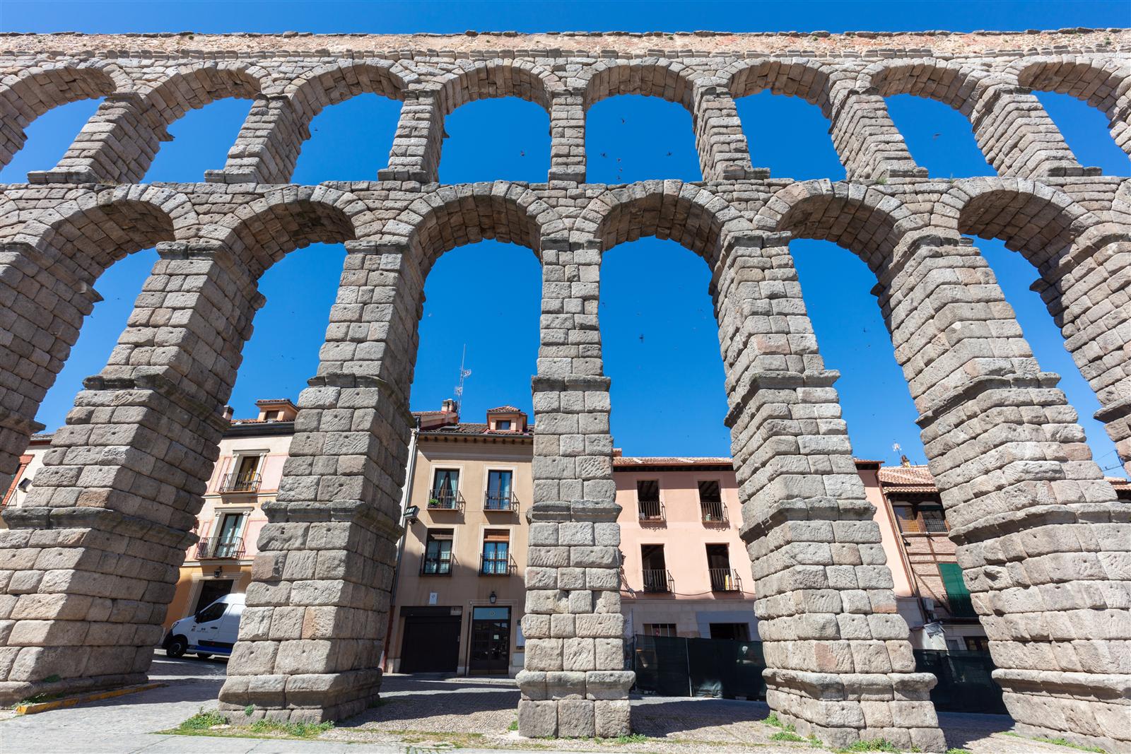El Acueducto de Segovia visto en perspectiva lateral, mostrando la sucesión de arcos de doble piso bajo la luz del sol, Segovia, Castilla y León