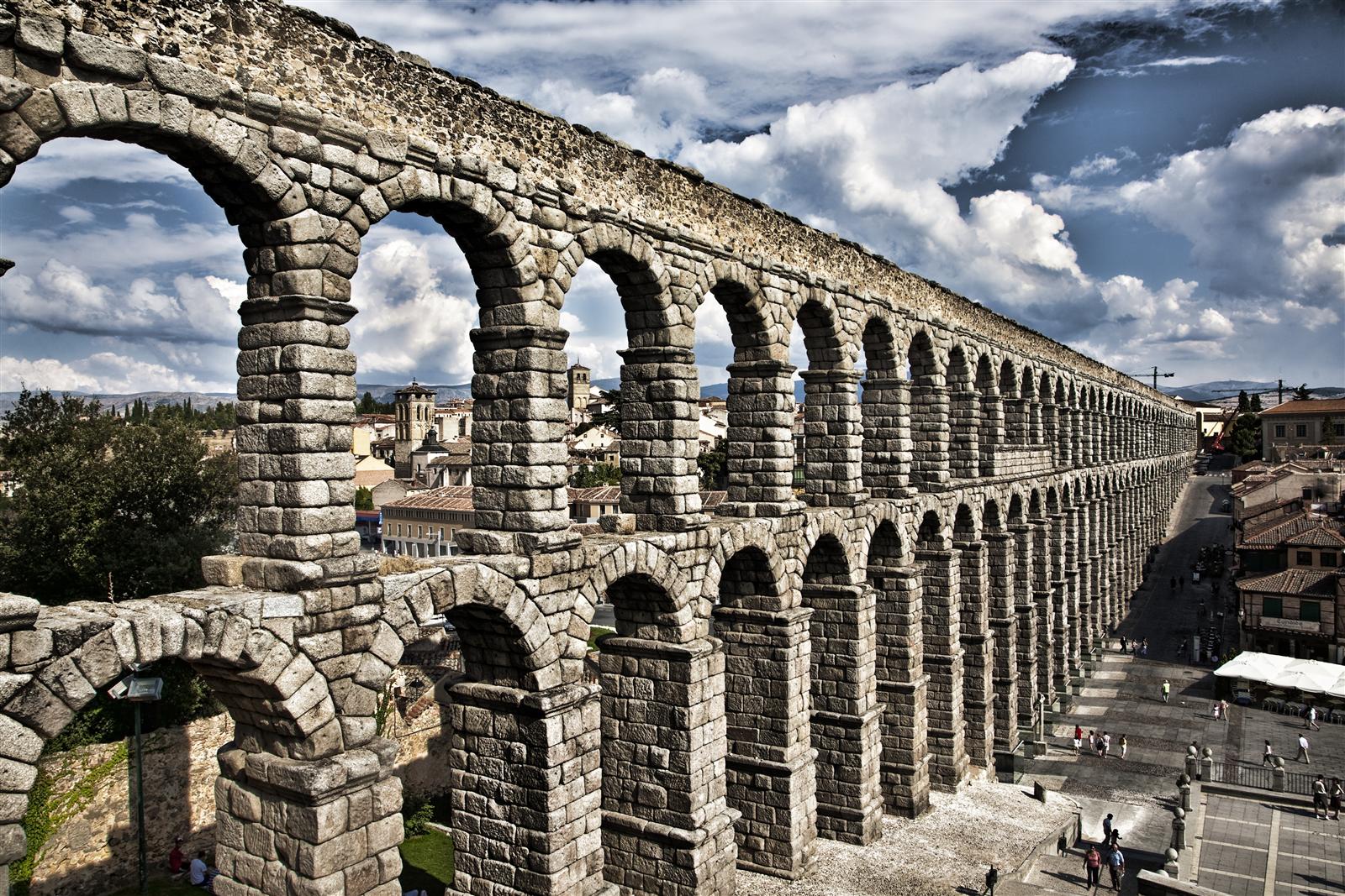 Detalle de los arcos del Acueducto Romano de Segovia con la ciudad medieval al fondo, sillares de granito sin argamasa, Segovia