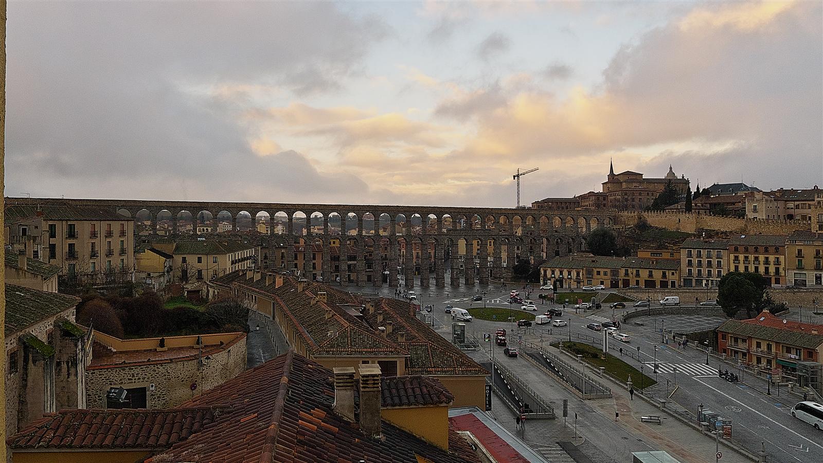 Acueducto de Segovia y Plaza de la Artillería desde una perspectiva elevada, con los arcos romanos atravesando el tejido urbano histórico de Segovia, Castilla y León