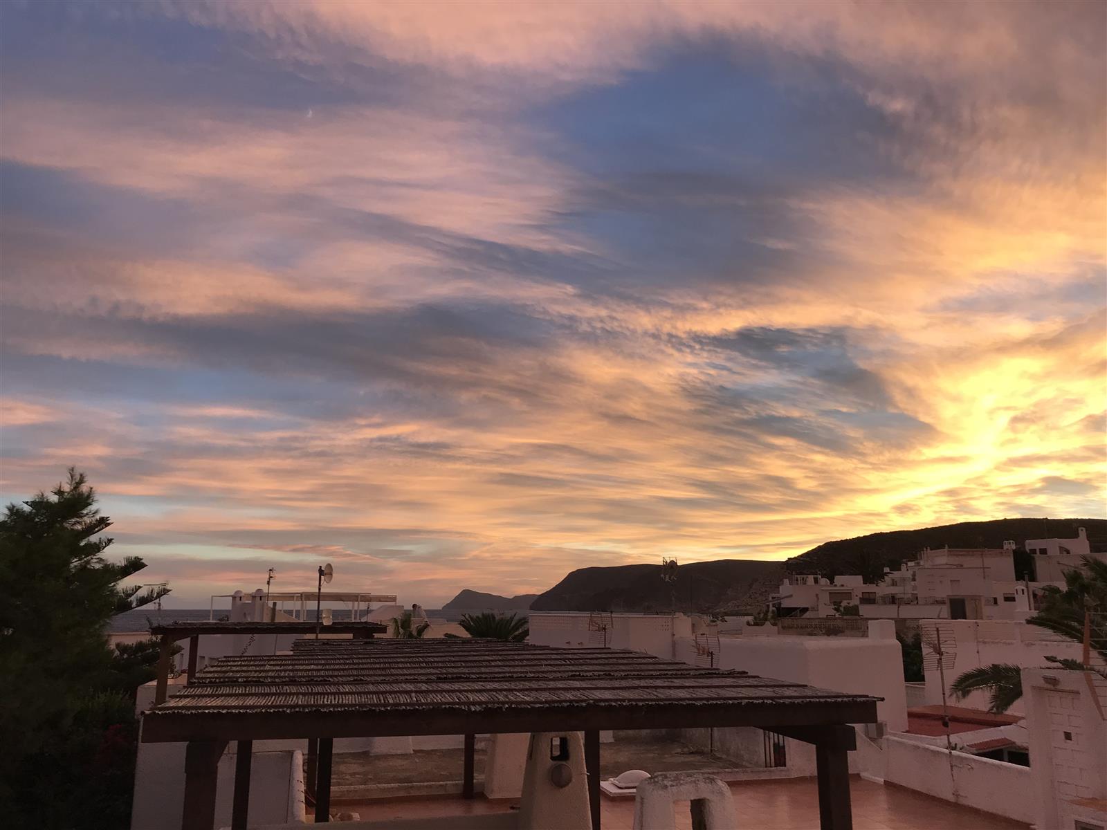 Cielo al anochecer sobre Agua Amarga con tonos rosados y azules reflejados en el mar tranquilo