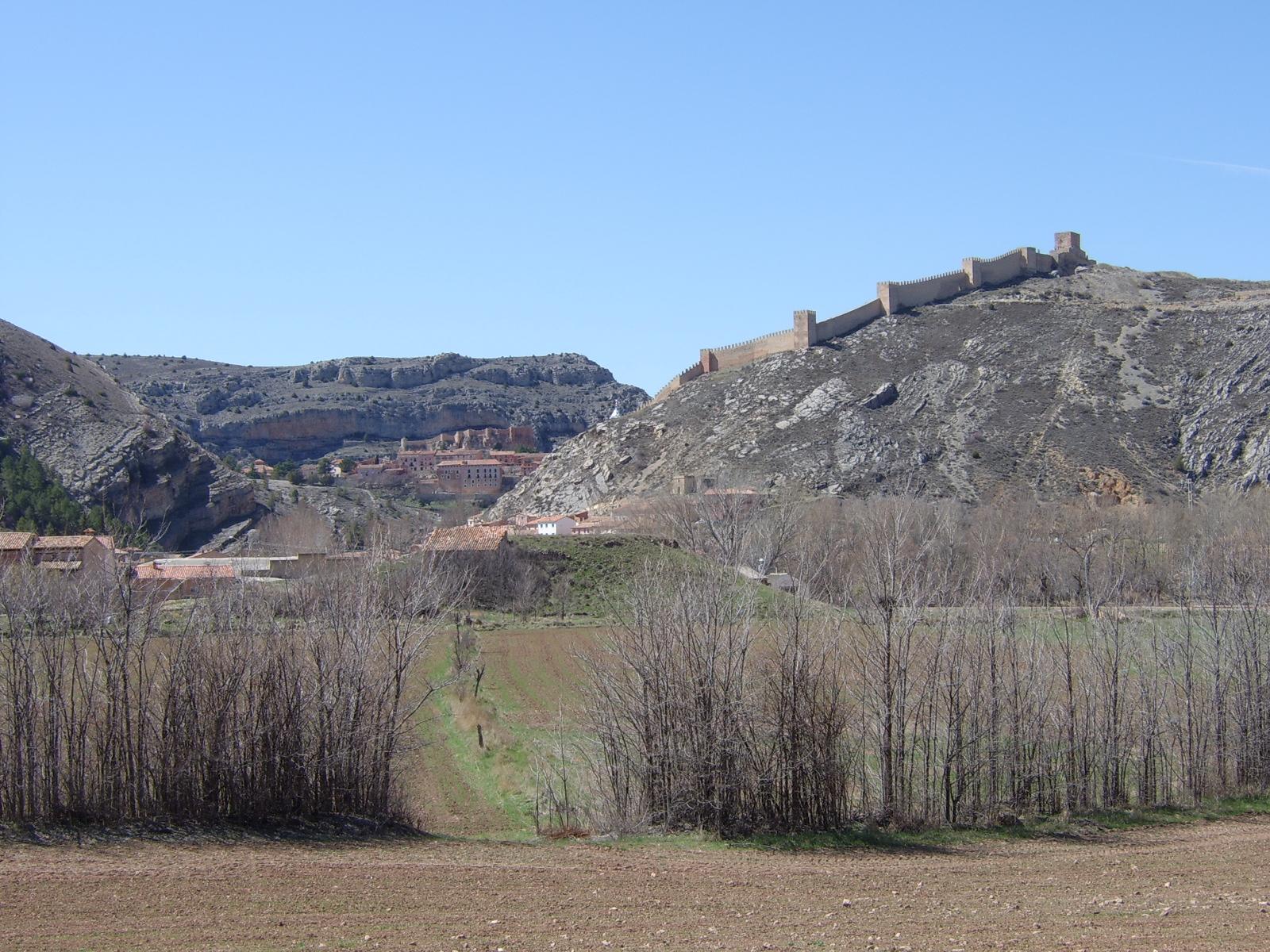 Murallas medievales de Albarracín: lienzos de piedra rojiza que rodean la ladera del pueblo, con la mampostería característica de la arenisca de la sierra, Teruel