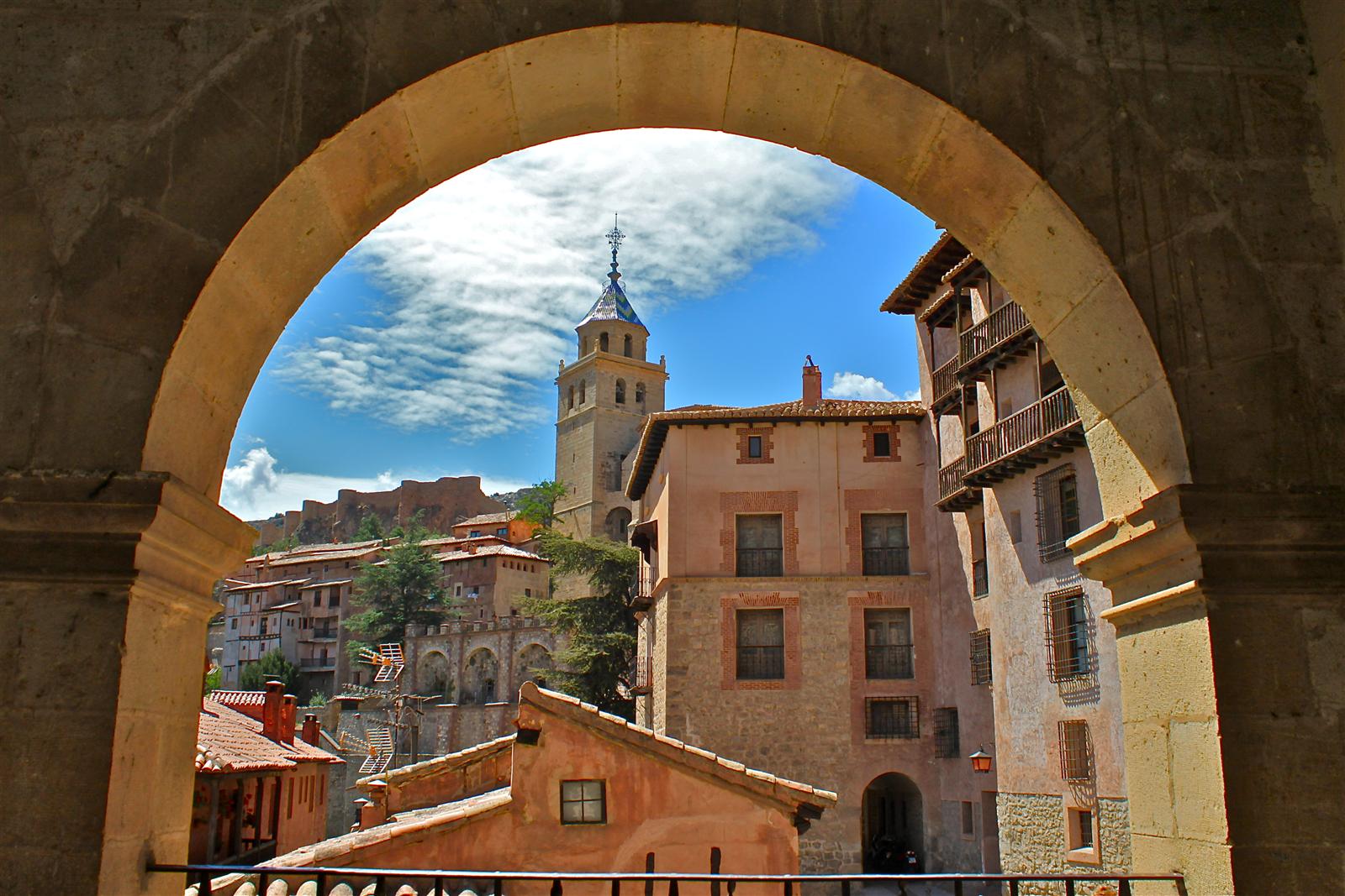 Catedral de Albarracín vista desde el Ayuntamiento: torre y fachada de piedra con el tejido histórico urbano de fondo, Teruel, Aragón