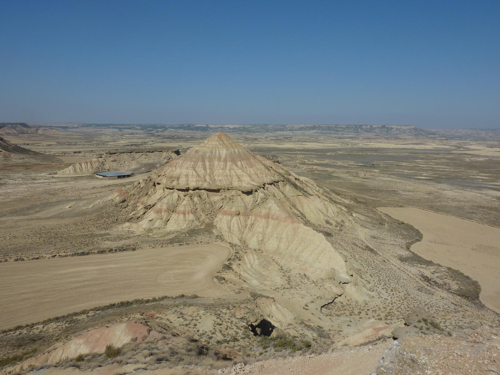 Vista elevada de la Bardena Blanca, con un cabezo y el paisaje de badlands al fondo