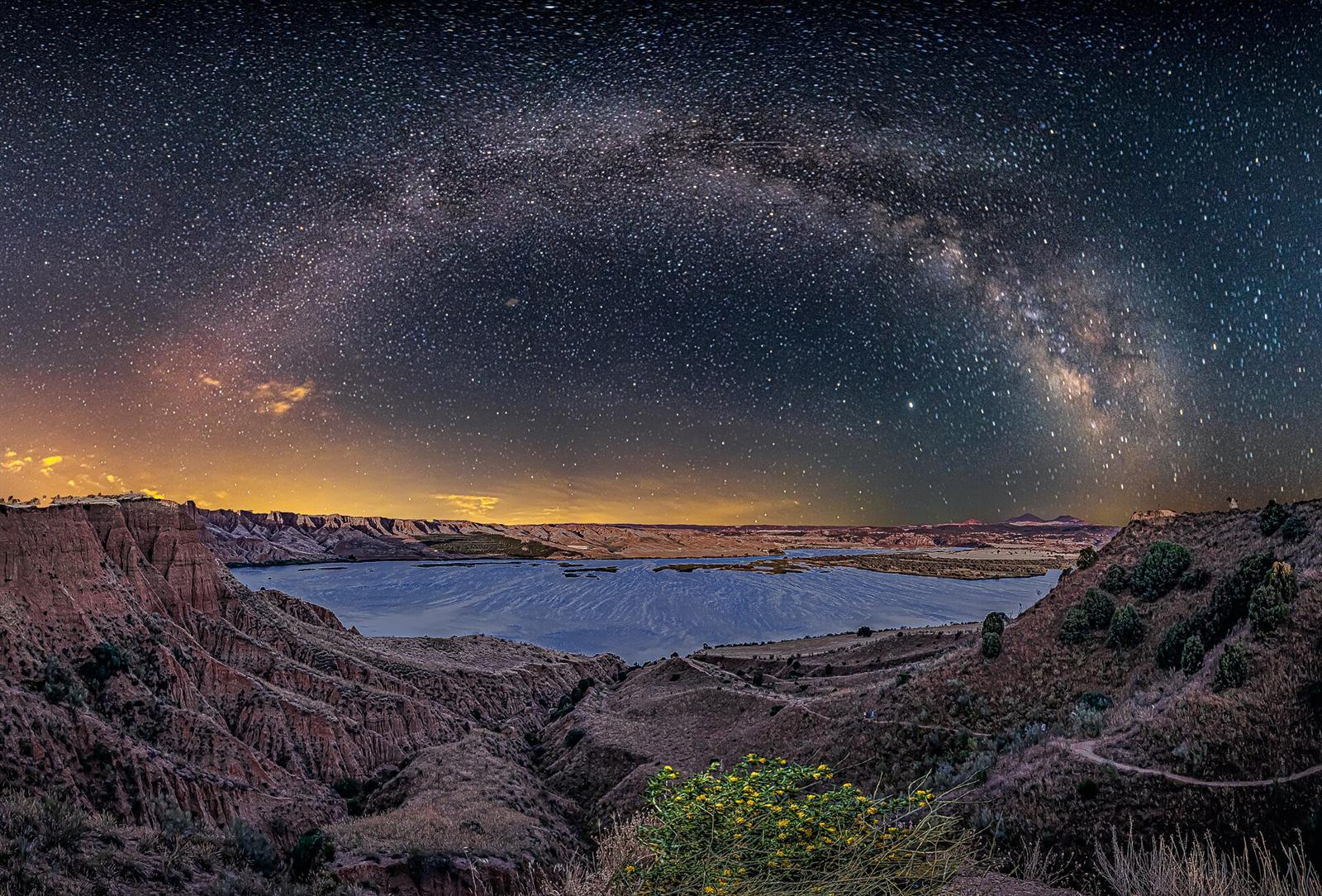 Vista nocturna de las Barrancas con la Vía Láctea sobre el embalse