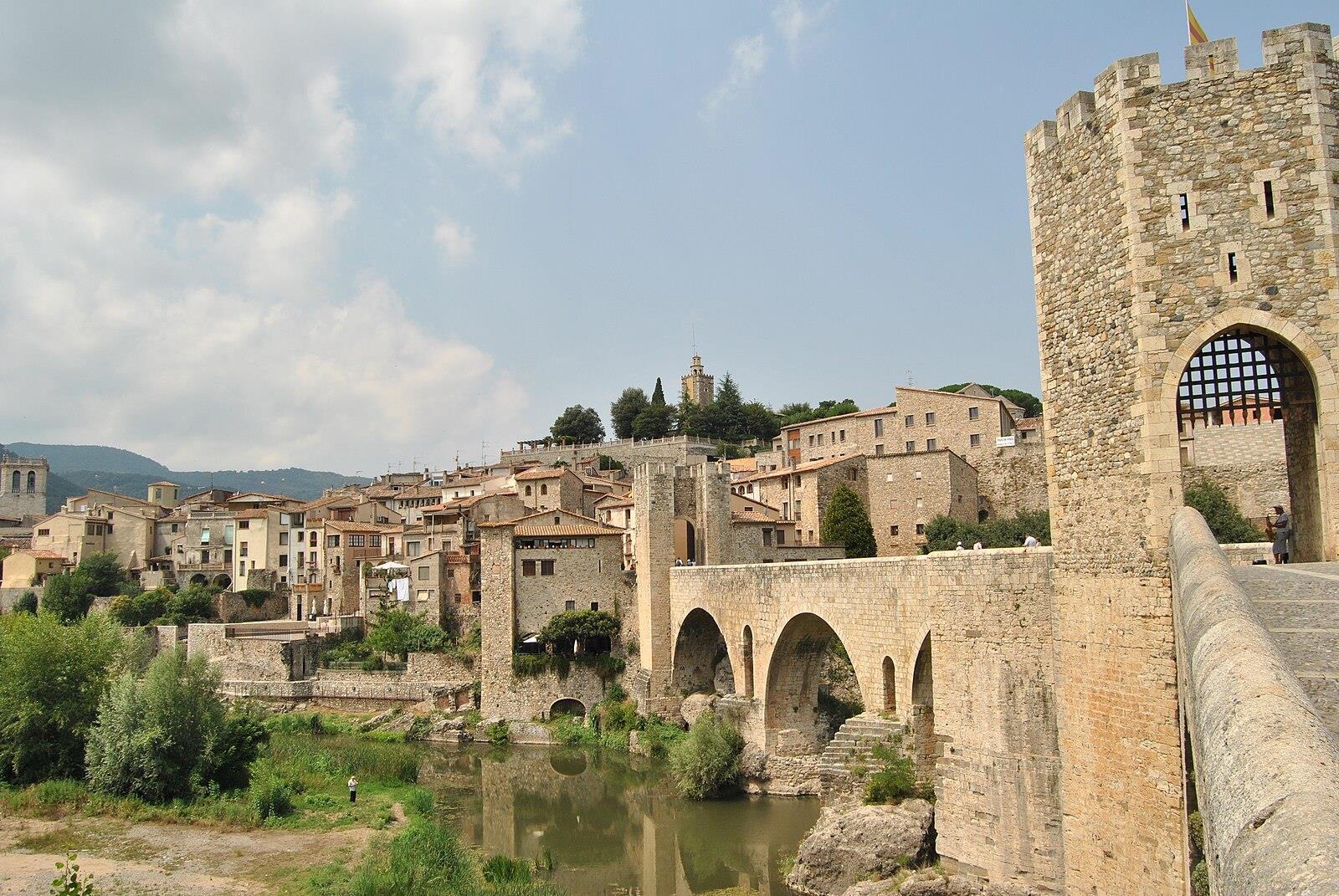 Vista desde la orilla del Fluvià del puente de Besalú con la torre en primer plano y el pueblo medieval al fondo