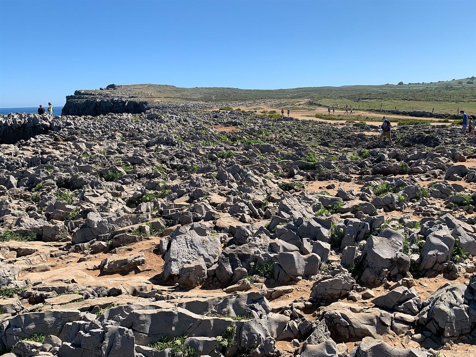 Terreno kárstico del sendero hacia los bufones, con visitantes caminando a distancia segura