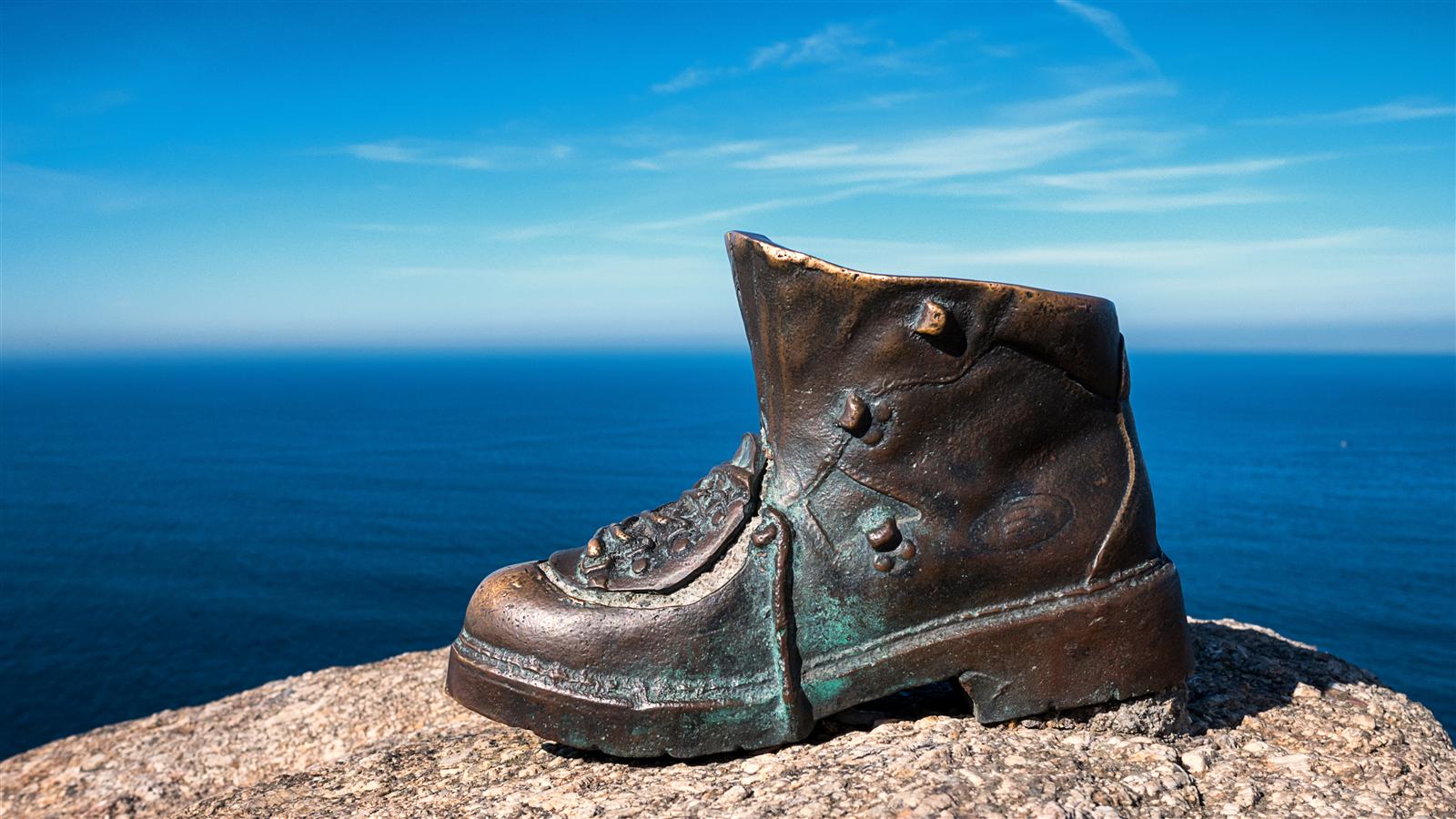 Escultura de las botas del peregrino en el extremo de Cabo Fisterra, junto al mojón 0,00 km del Camino de Santiago, Fisterra, Galicia