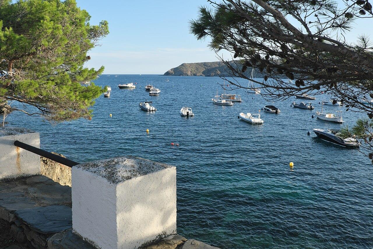 Detalle de pared blanca y bahía de Cadaqués con barcos fondeados, Costa Brava