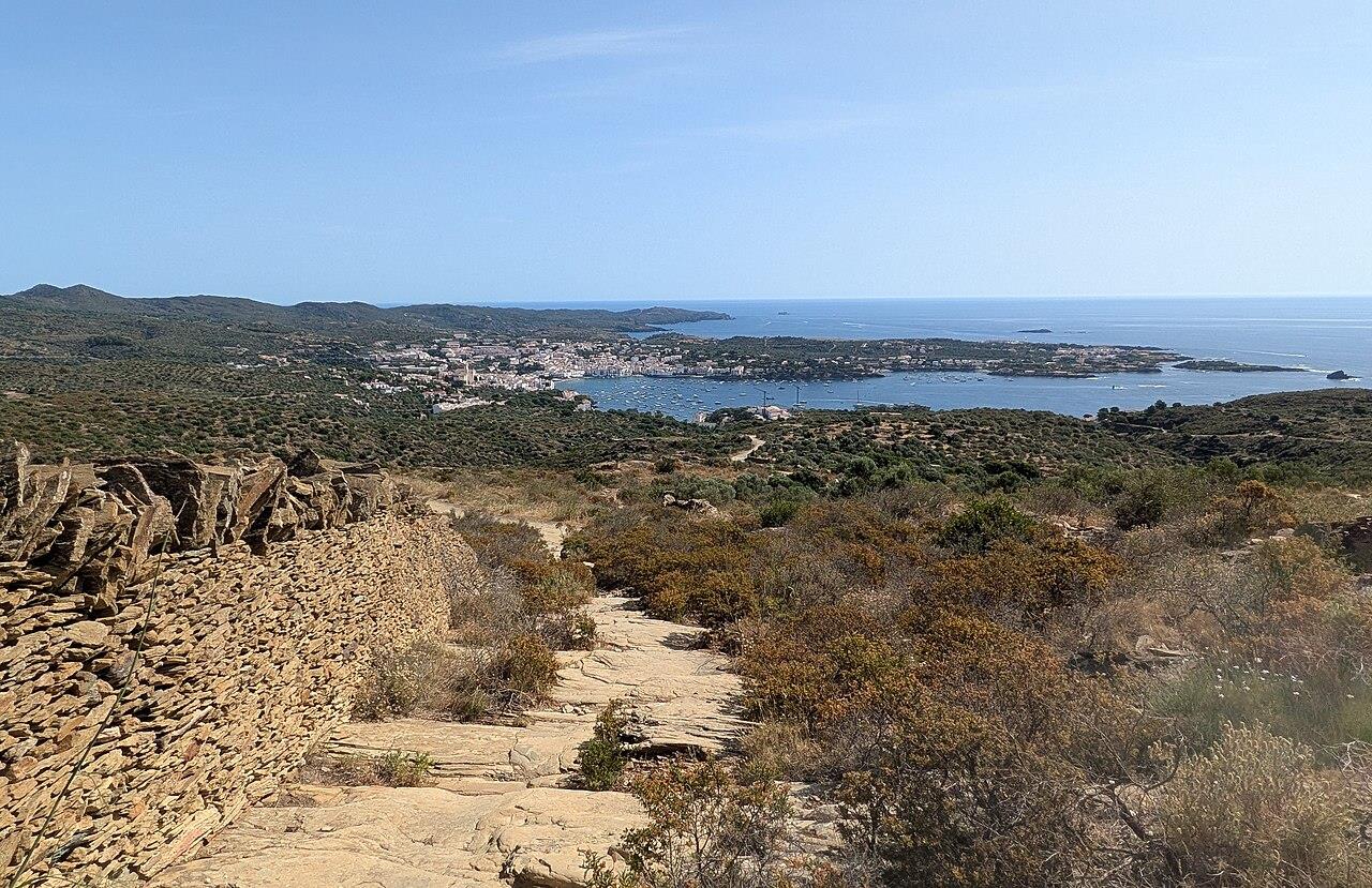 Camino de Ronda GR92 bajando hacia Cadaqués, con la bahía y el pueblo al fondo
