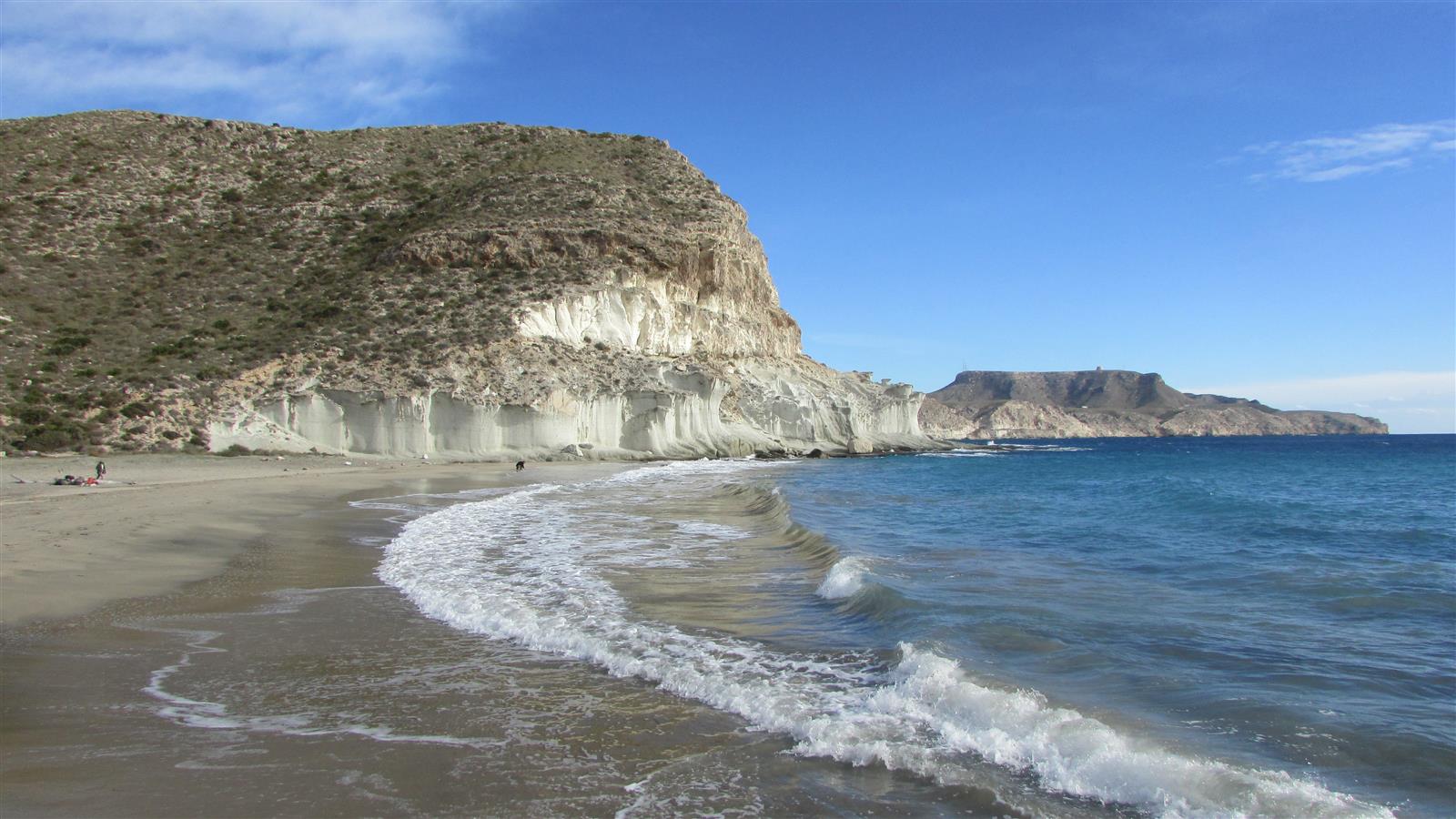Cala de Enmedio en Agua Amarga con arena dorada, acantilados volcánicos blancos y aguas transparentes en calma