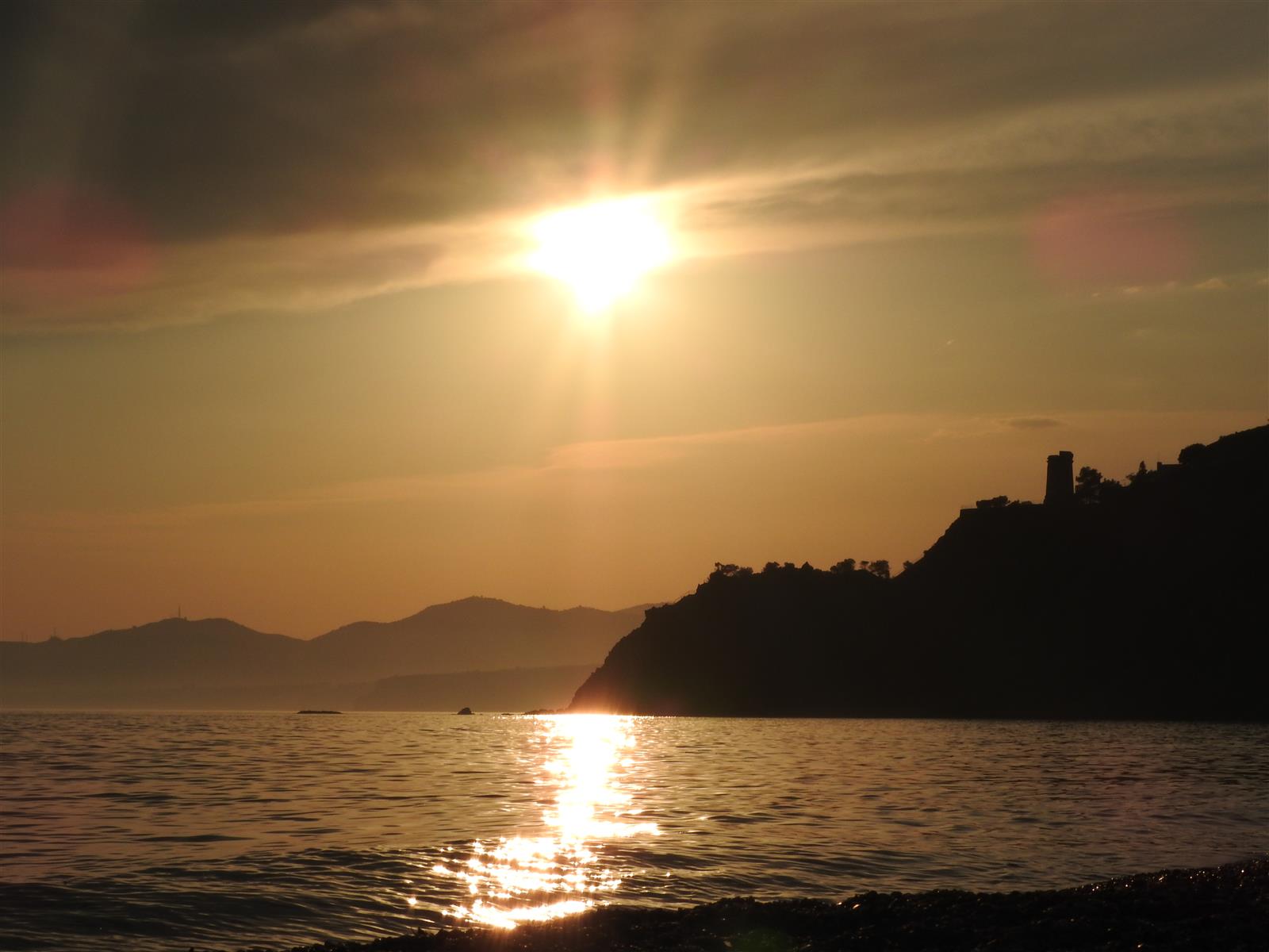 Atardecer desde Cala del Cañuelo en Maro con la silueta de los acantilados y Torre Caleta al fondo