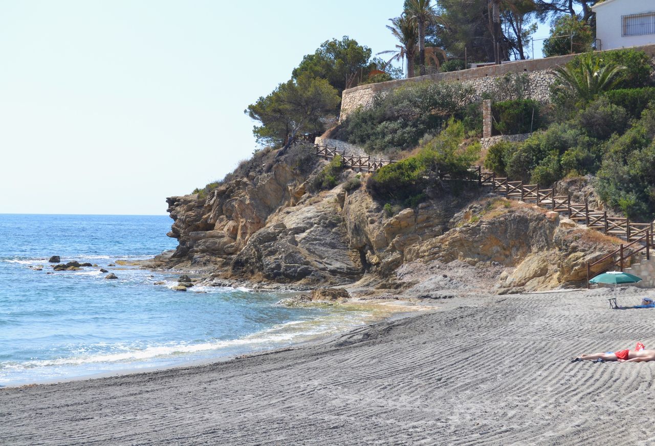 Vista de la Cala de la Fustera con arena y acantilados en Benissa