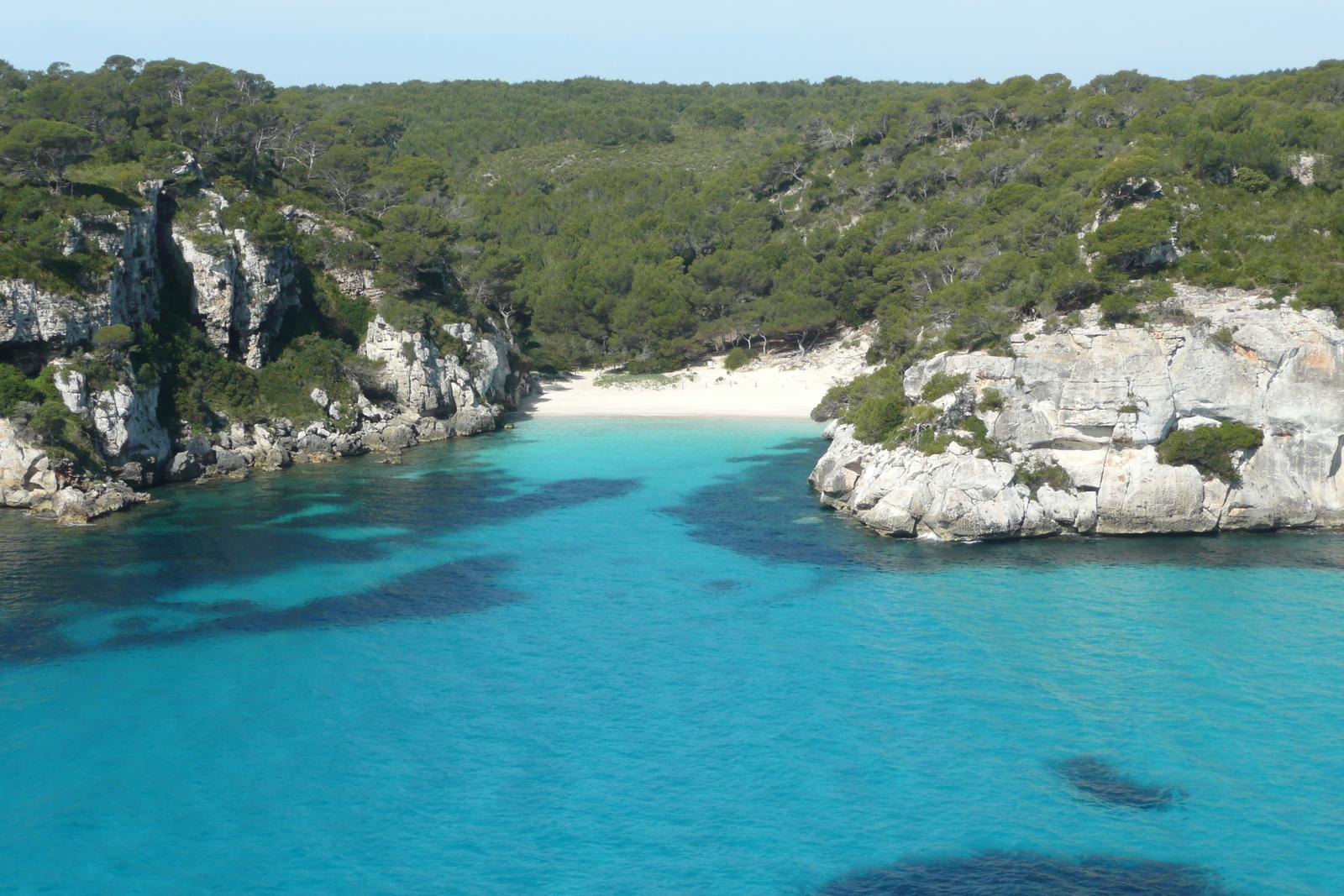 Vista aérea de Cala Macarelleta y su acceso a pie entre pinares