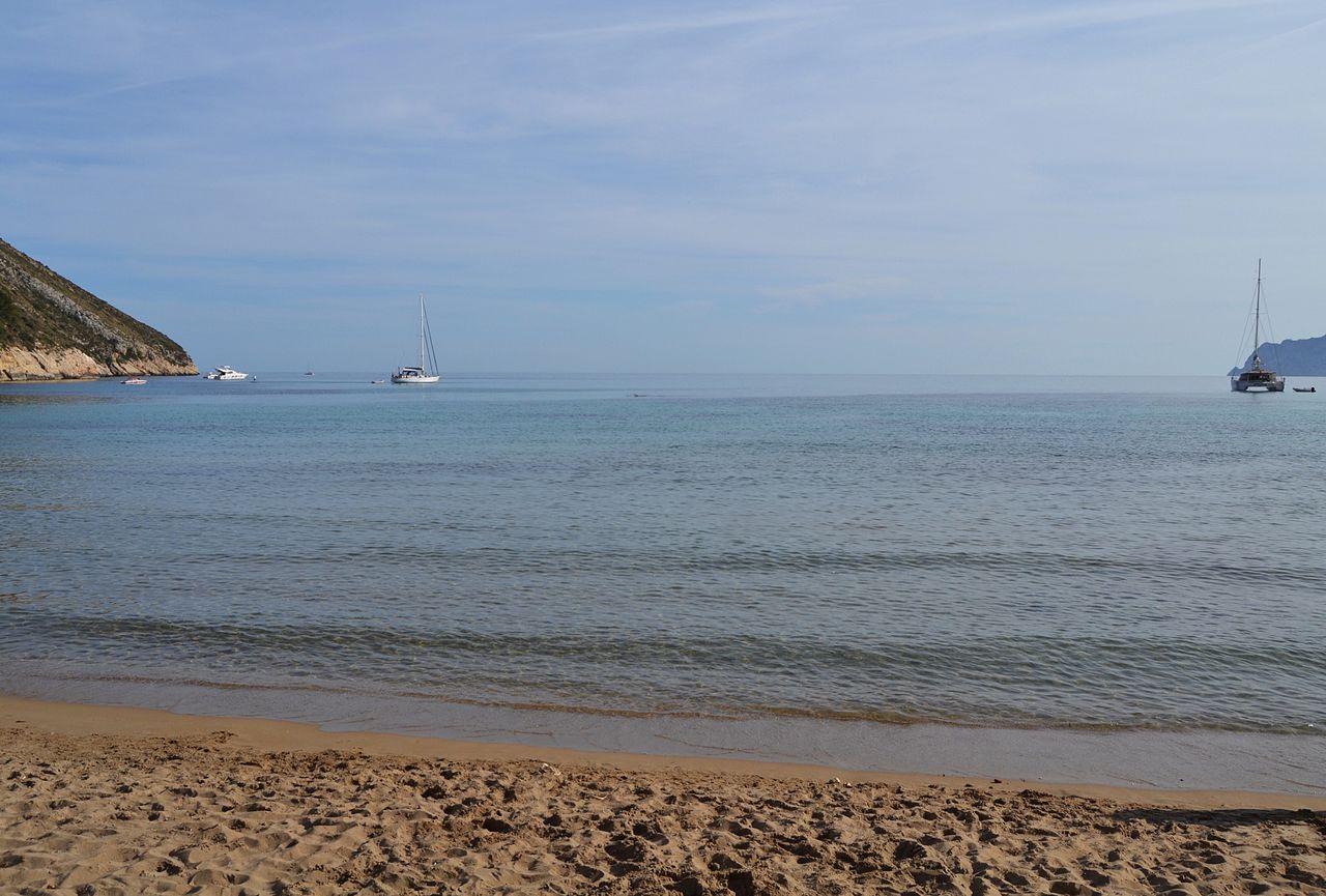 Cala del Portet de Moraira con aguas tranquilas y costa mediterránea, Alicante