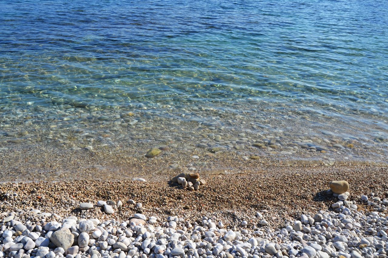 Orilla de la Cala Portitxol con cantos y agua turquesa