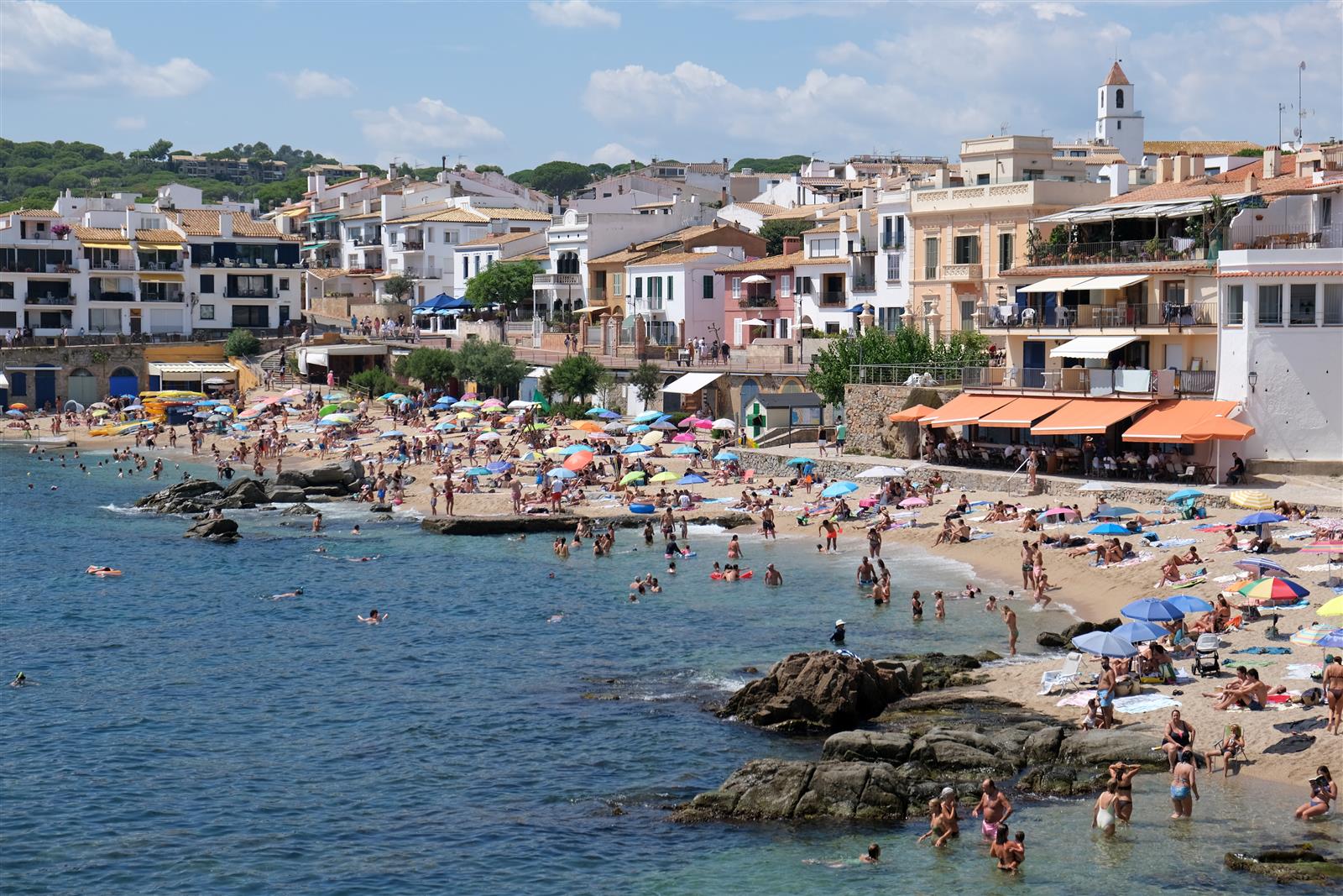 Platja del Canadell de Calella de Palafrugell con el campanario de Sant Pere al fondo y las casas blancas frente al mar