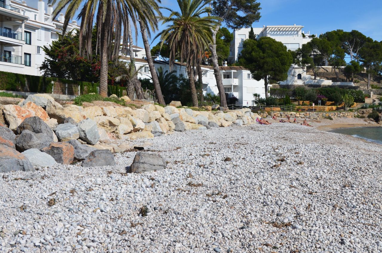 Playa de Cap Negret con cantos negros volcánicos y agua verde esmeralda en Altea