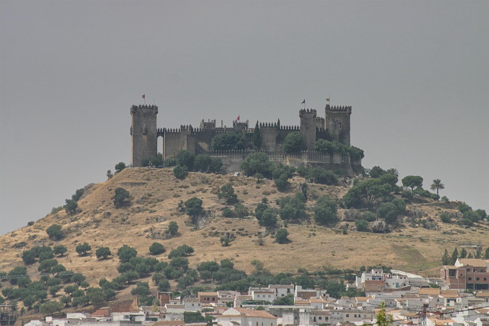 Vista exterior del Castillo de Almodóvar del Río sobre el cerro, con sus torres y murallas medievales y el pueblo al pie, Córdoba