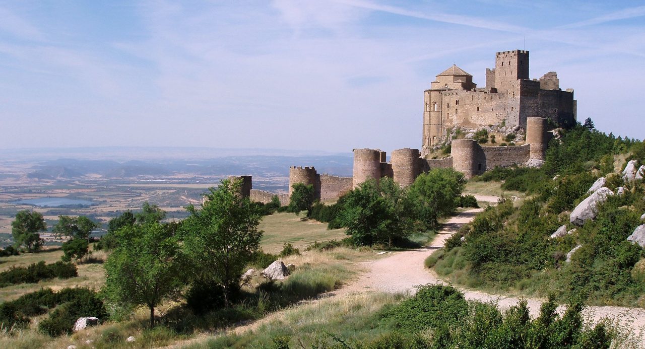 El Castillo de Loarre con el pueblo de Loarre y el paisaje del prepirineo de Huesca al fondo