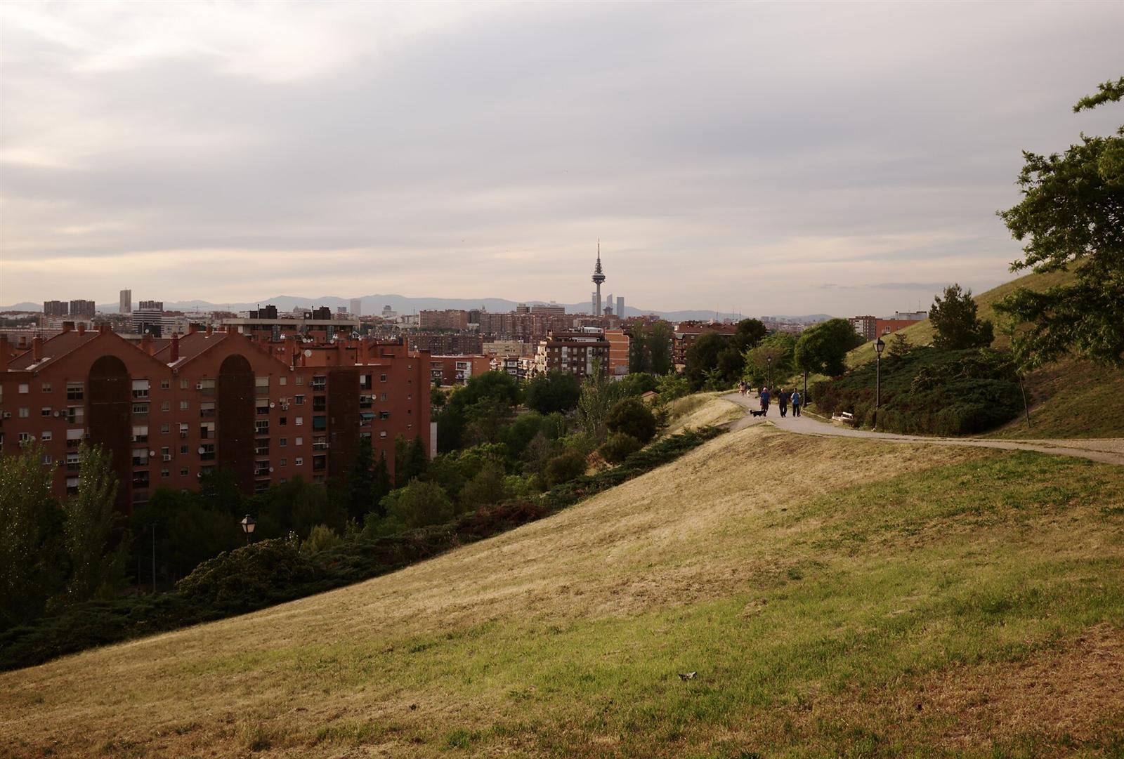 Sendero sobre una de las colinas con paseantes y el skyline al fondo