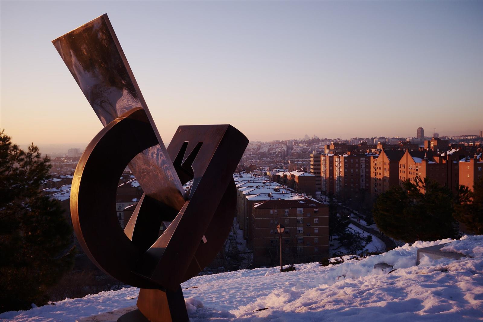 Escultura Rectángulo real ilusorio en lo alto del parque, con la ciudad al fondo