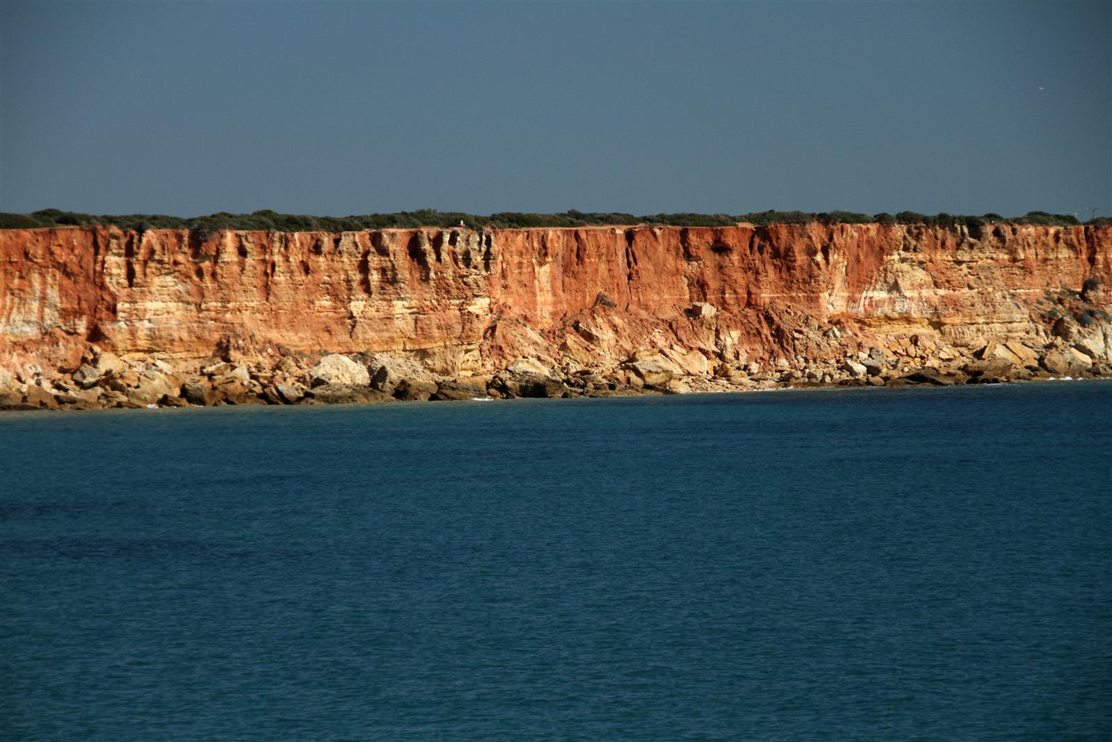 Acantilados rojizos de la Cala del Aceite en Conil de la Frontera sobre el Atlántico, Costa de la Luz, Cádiz