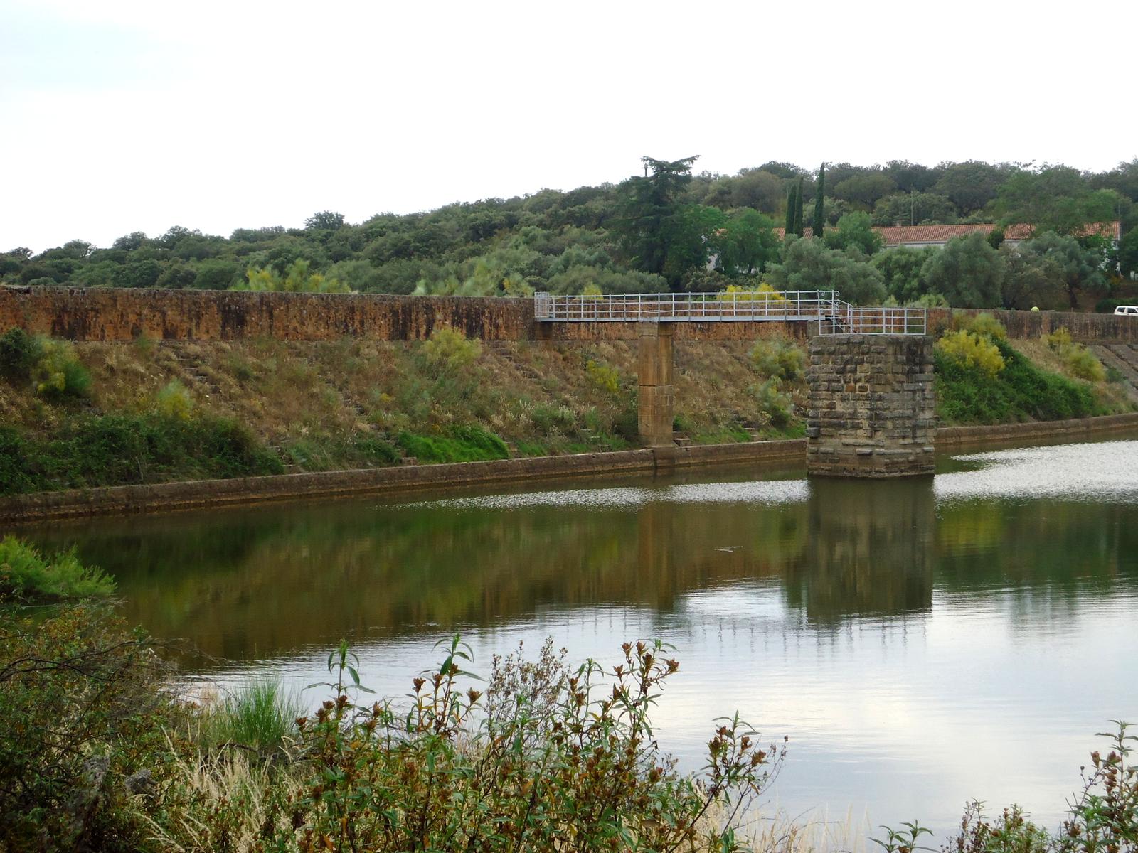 Presa romana del Embalse de Cornalvo reflejada en el agua