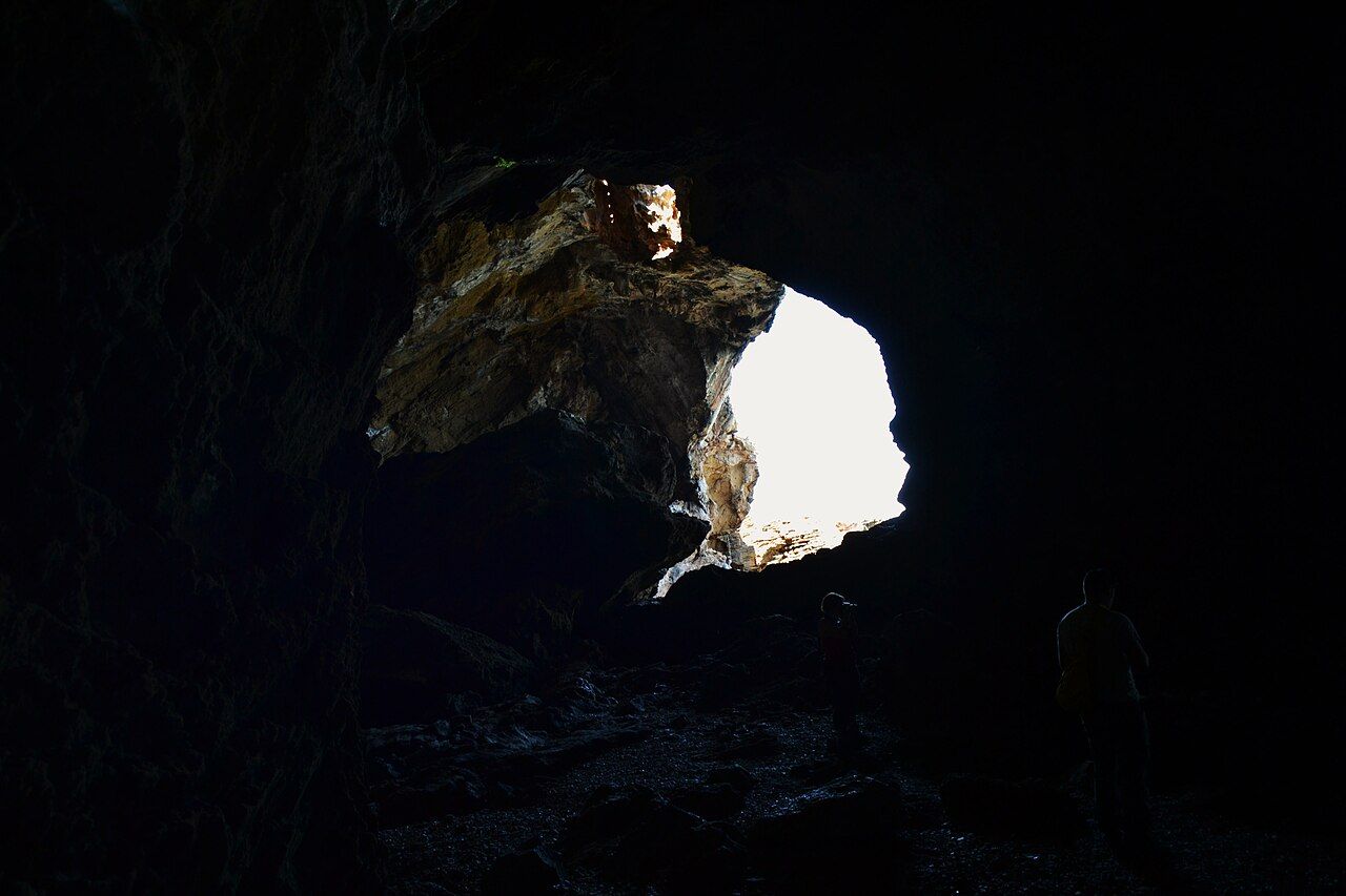 Interior de la Cova Tallada con las paredes de roca y la luz natural