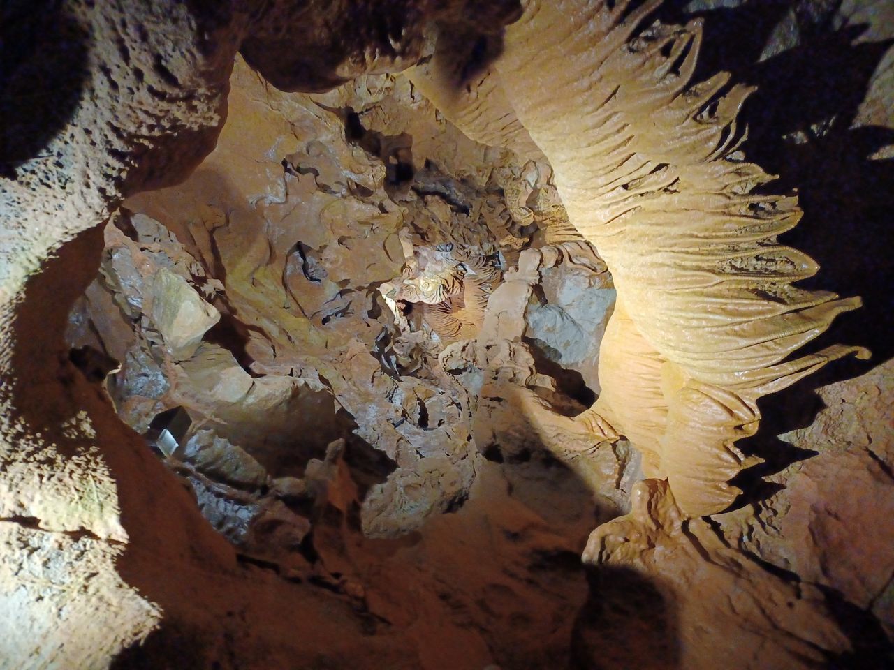 Interior de las Coves de Sant Josep con el río subterráneo y formaciones de calcita