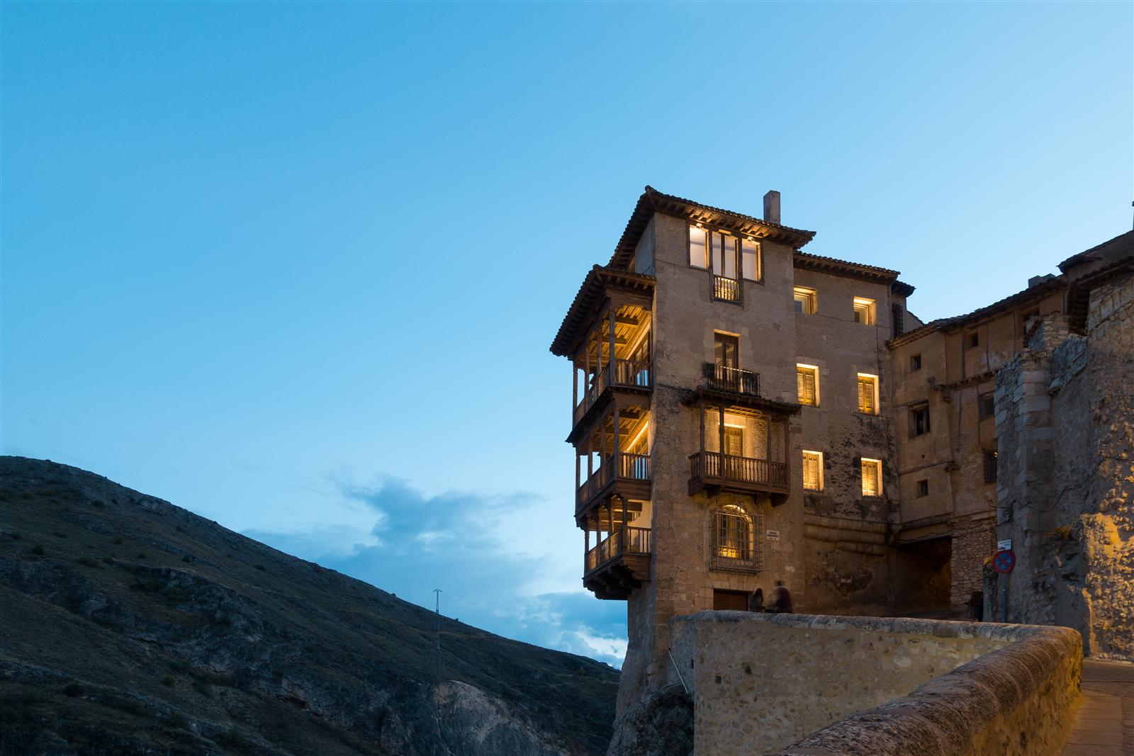 Casas Colgadas de Cuenca iluminadas al atardecer, balcones de madera sobre el tajo del río Huécar