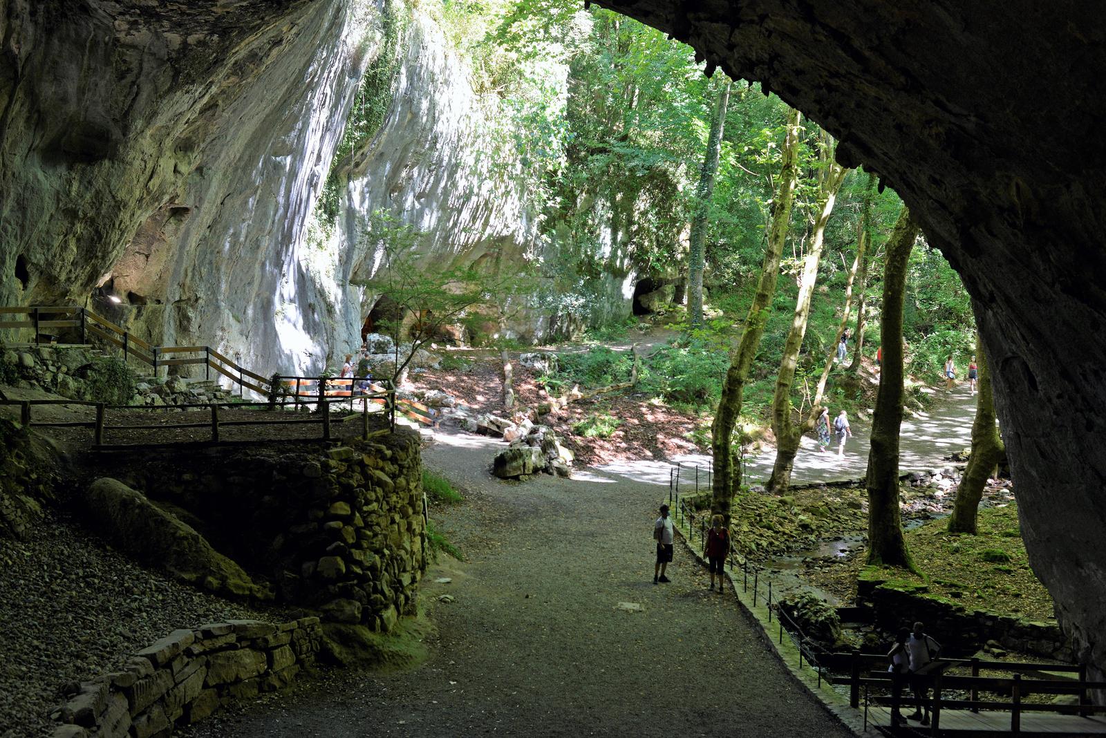 Galería interior de las Cuevas de Zugarramurdi con las formaciones kársticas y la vegetación asomando por los extremos