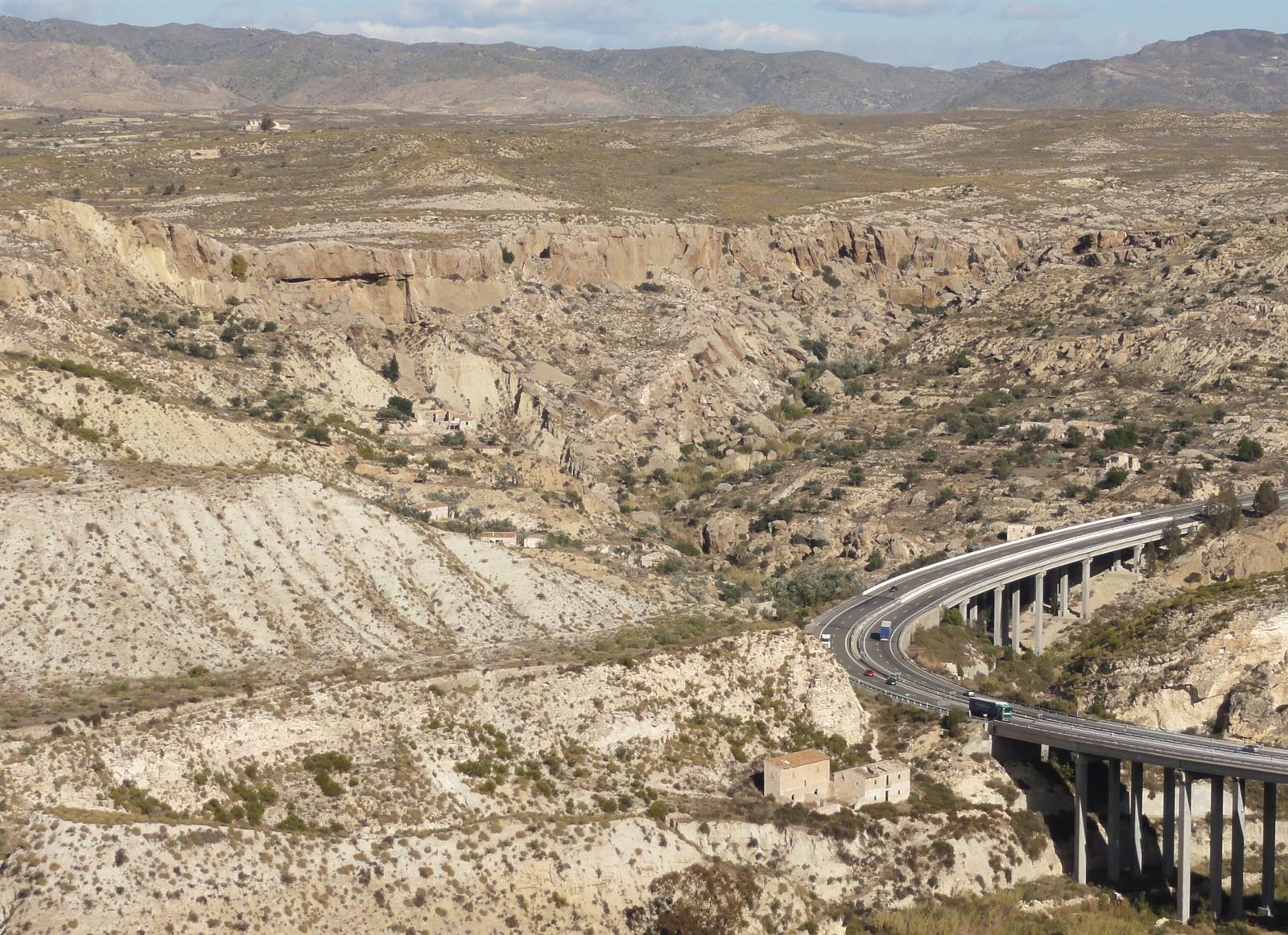 Unidad geológica de los yesos de Sorbas, vista del paisaje de barrancos y colinas de yeso con la autovía al fondo, Paraje Natural de Almería