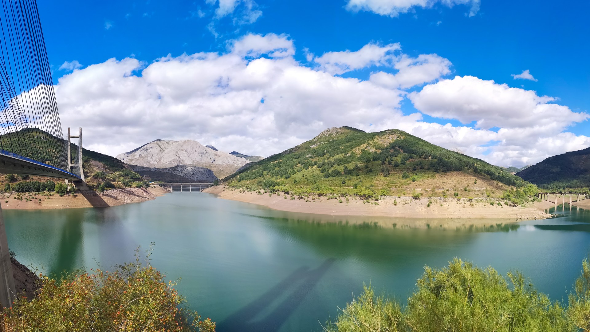 Embalse de Barrios de Luna con el viaducto atirantado y las montañas leonesas reflejadas en el agua