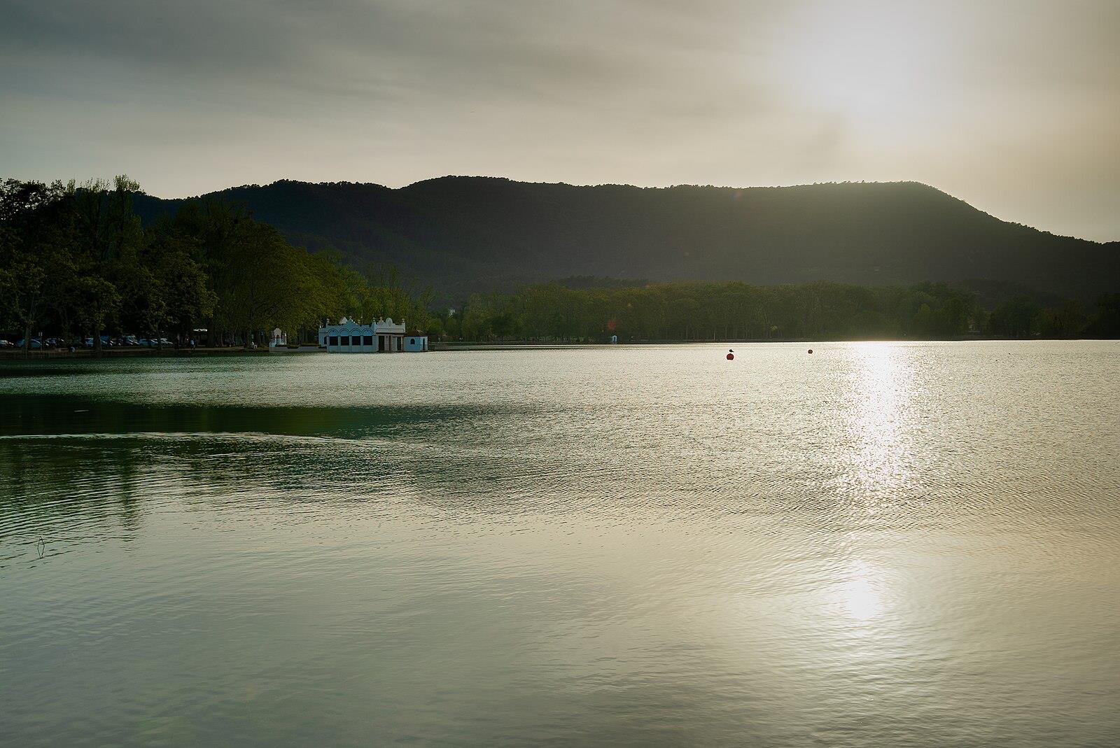Vista del Estany de Banyoles al atardecer con la caseta blanca de pescadores y las montañas de la Garrotxa al fondo, Girona