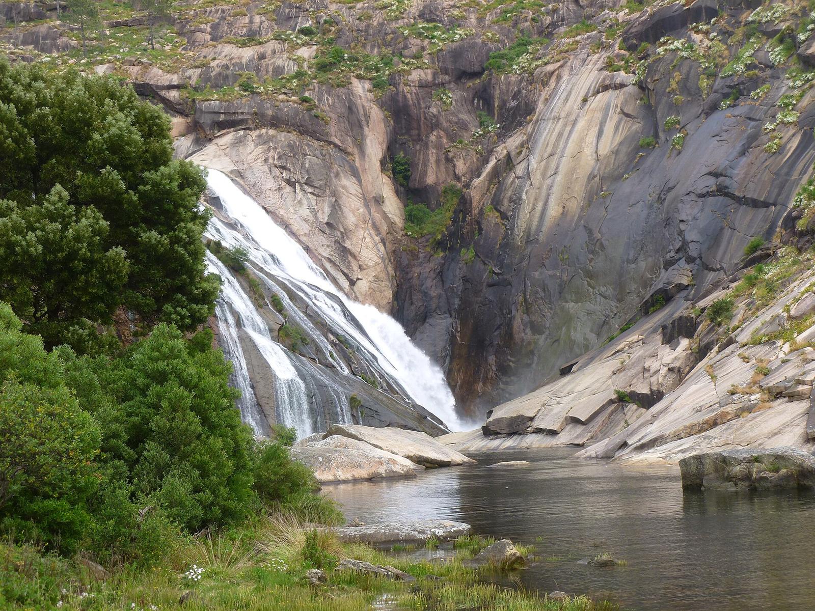 Vista completa de la cascada con la pasarela de acceso al fondo
