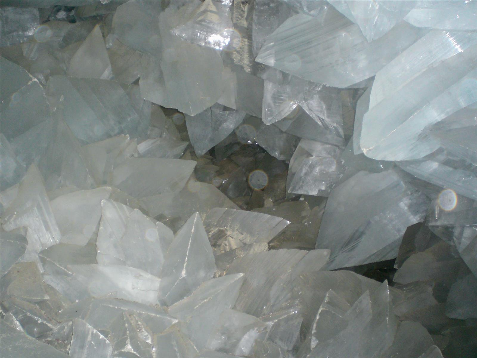 Interior de la Geoda de Pulpí con cristales de yeso traslúcidos agrupados que dejan ver la roca de la pared a través de ellos, detalle fotográfico
