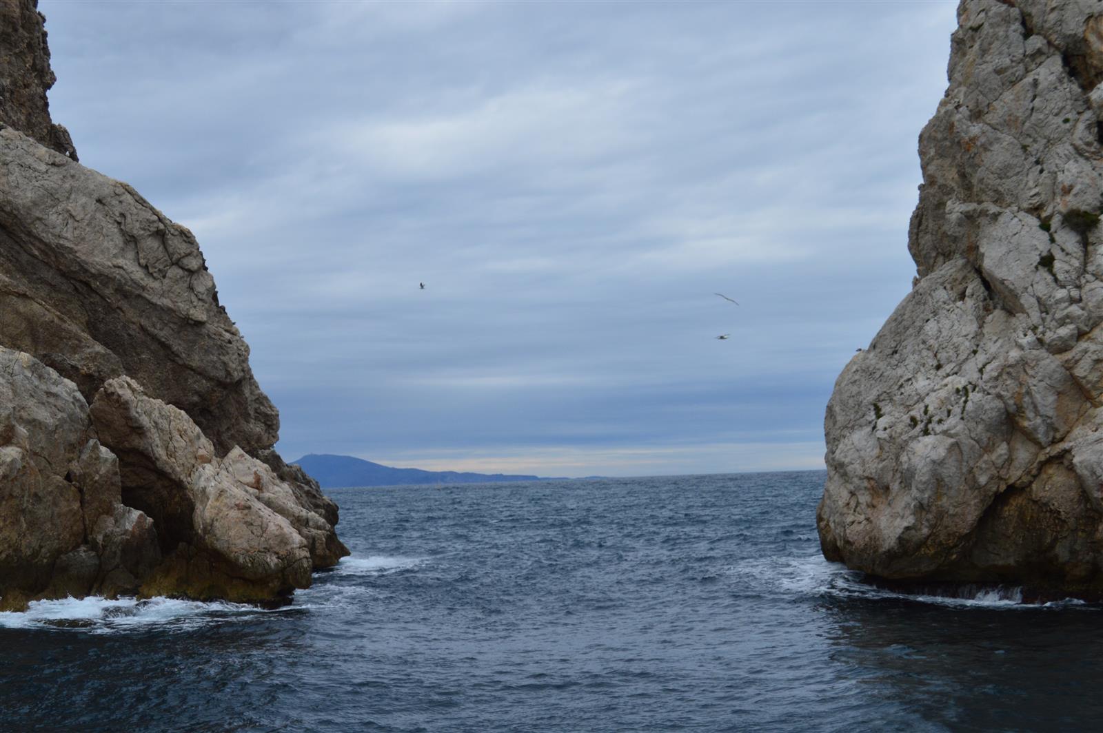 Perspectiva desde las rocas de las Illes Medes: paso entre dos paredes de roca con vistas al mar abierto de la Costa Brava
