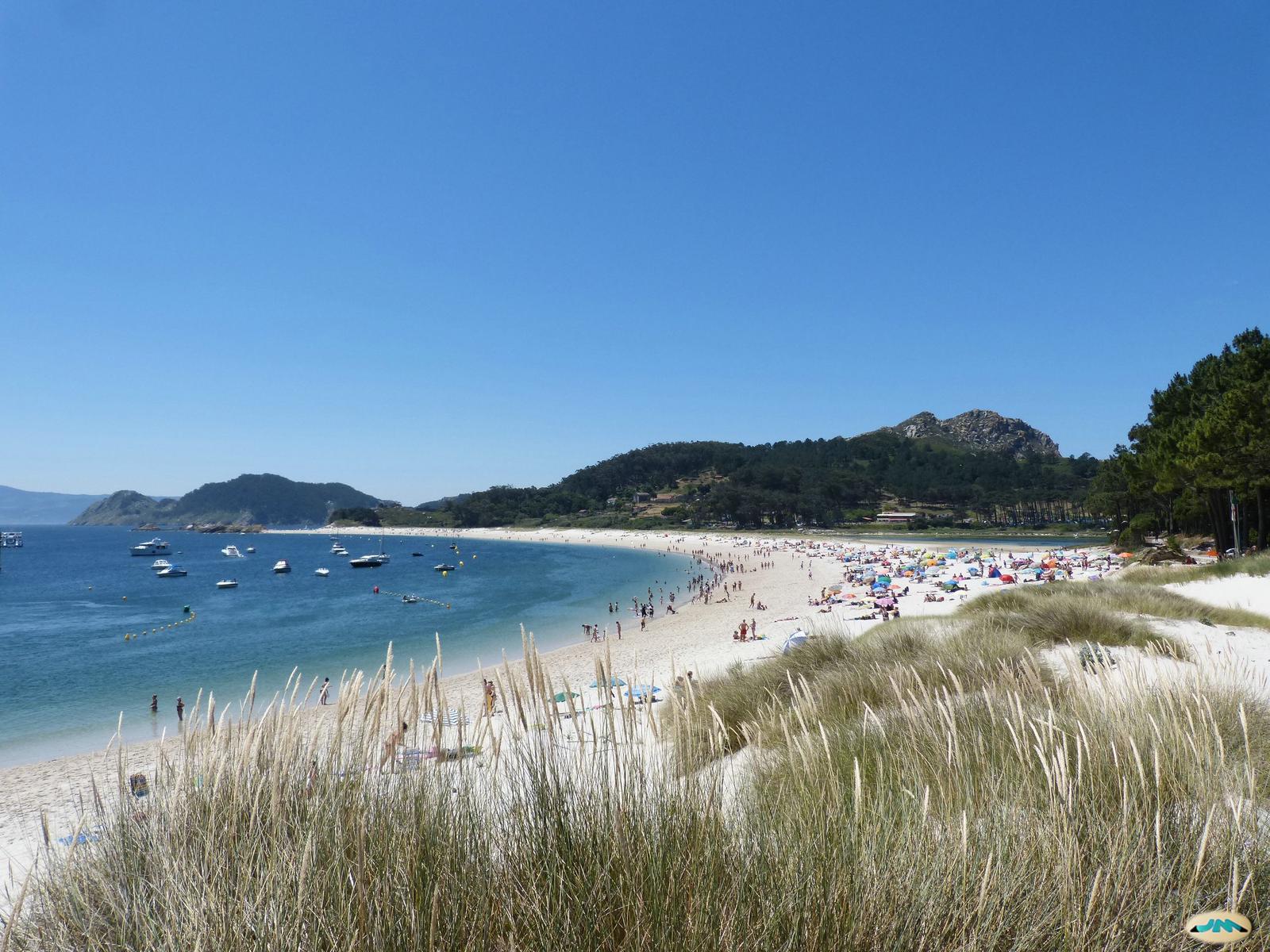 La Playa de Rodas vista desde las dunas, con la Ría de Vigo, barcos fondeados y el monte al fondo