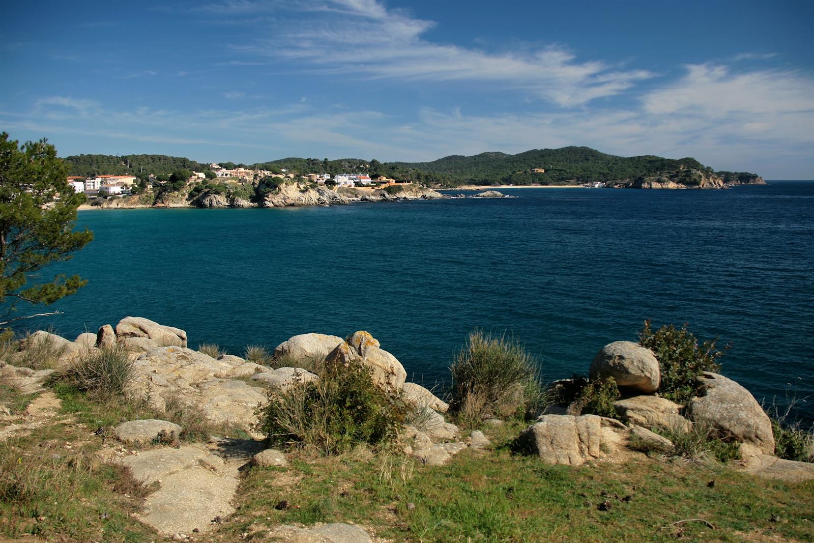 Paisaje rocoso y mar azul intenso con la bahía de La Fosca y el Cap Gros al fondo, Baix Empordà