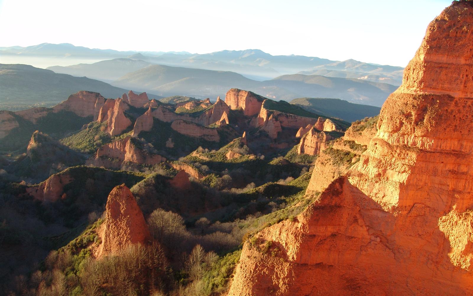 Formaciones de roca roja de Las Médulas iluminadas por luz dorada