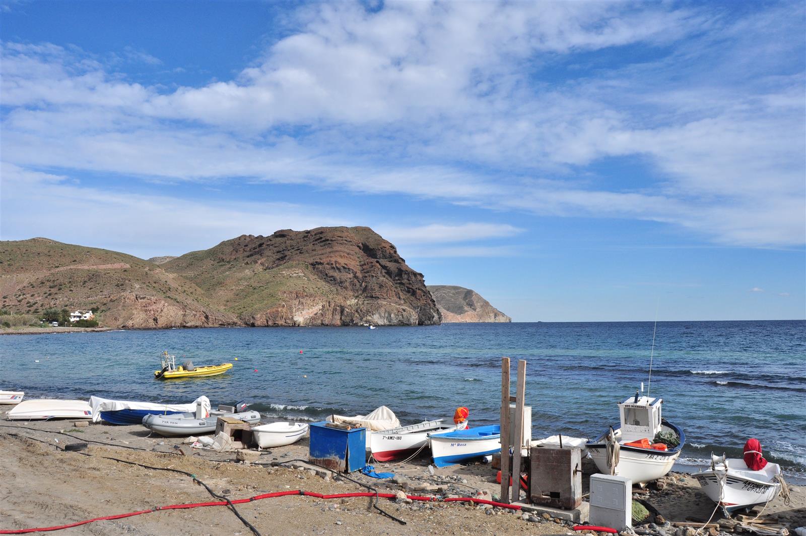 Barcas de pesca en la playa de Las Negras con los acantilados volcánicos de Cabo de Gata