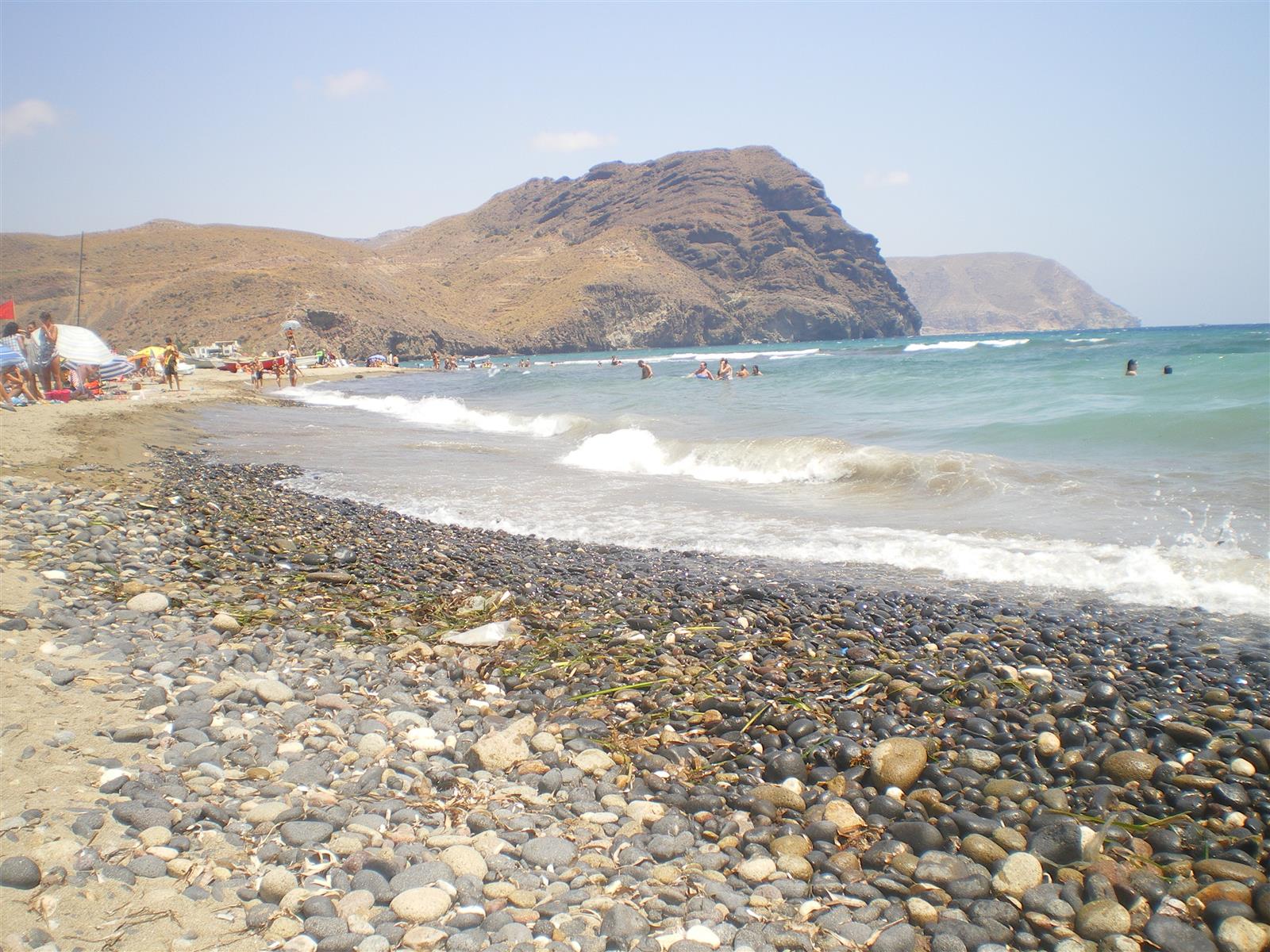 Playa de Las Negras con el Cerro Negro volcánico y las olas del Mediterráneo sobre la arena oscura