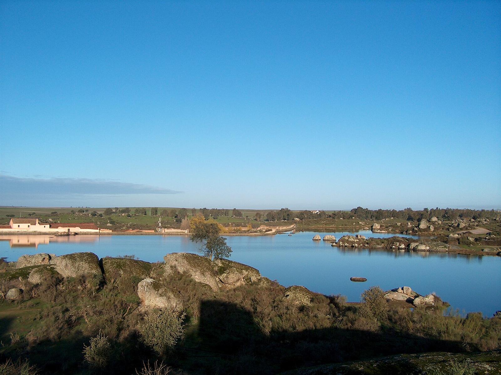 Vista amplia de la charca con el antiguo lavadero al fondo