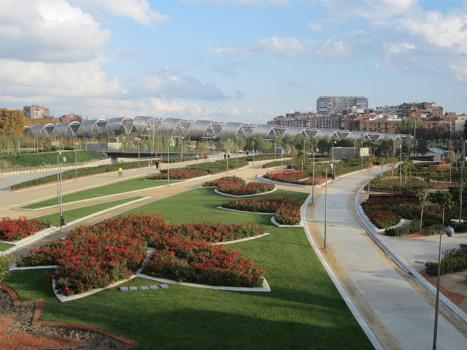 Zona ajardinada del Parque de Arganzuela con el puente al fondo