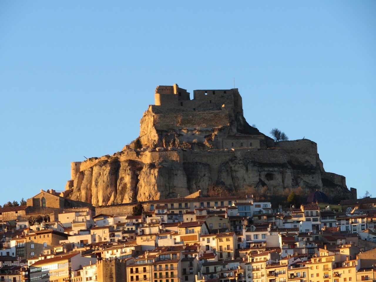 Morella al atardecer — vista de la villa medieval con el castillo al fondo