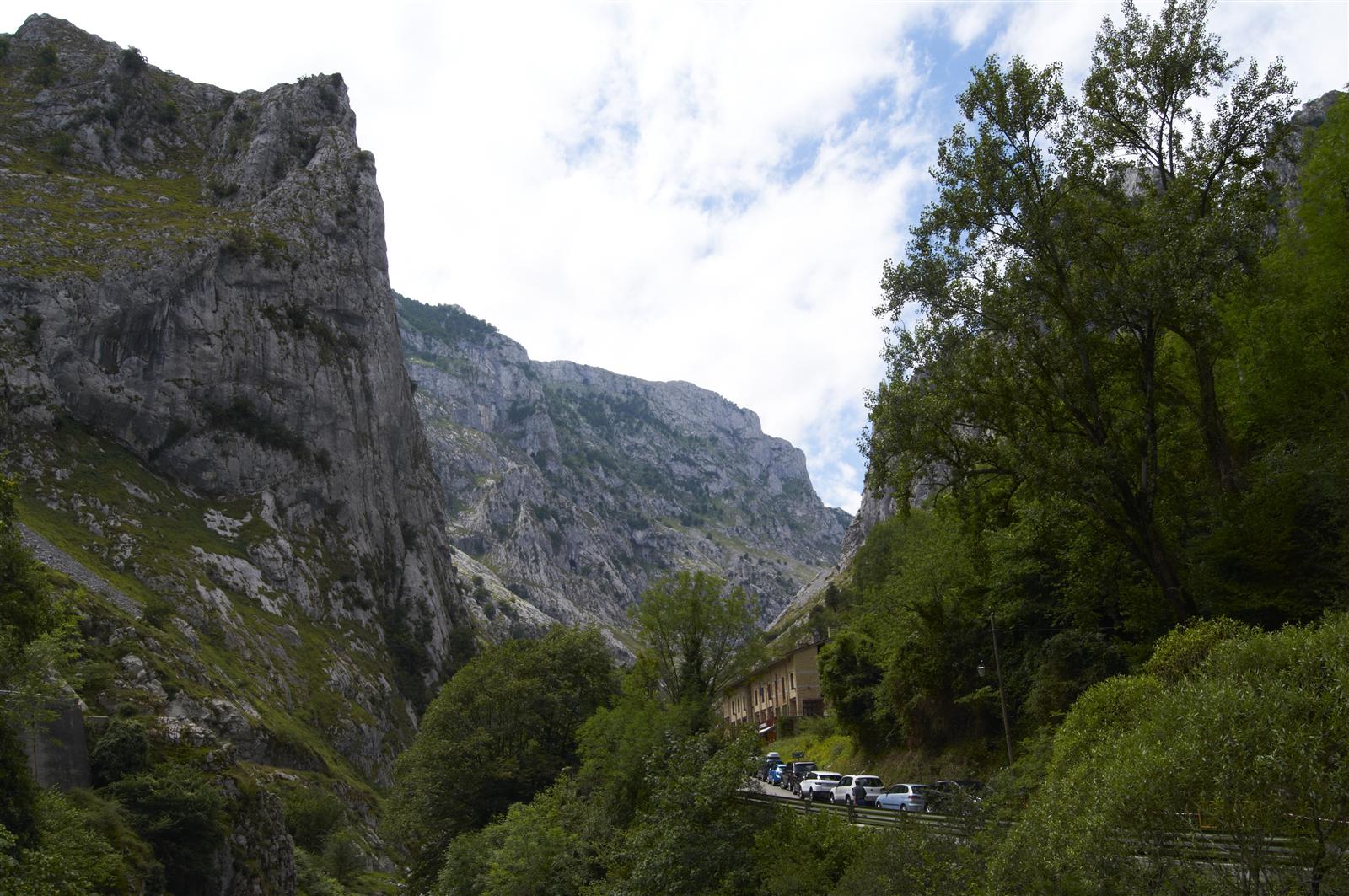 Vista clásica del Naranjo de Bulnes desde el valle, mostrando la característica pared de caliza naranja-dorada sobre el circo glaciar, Picos de Europa