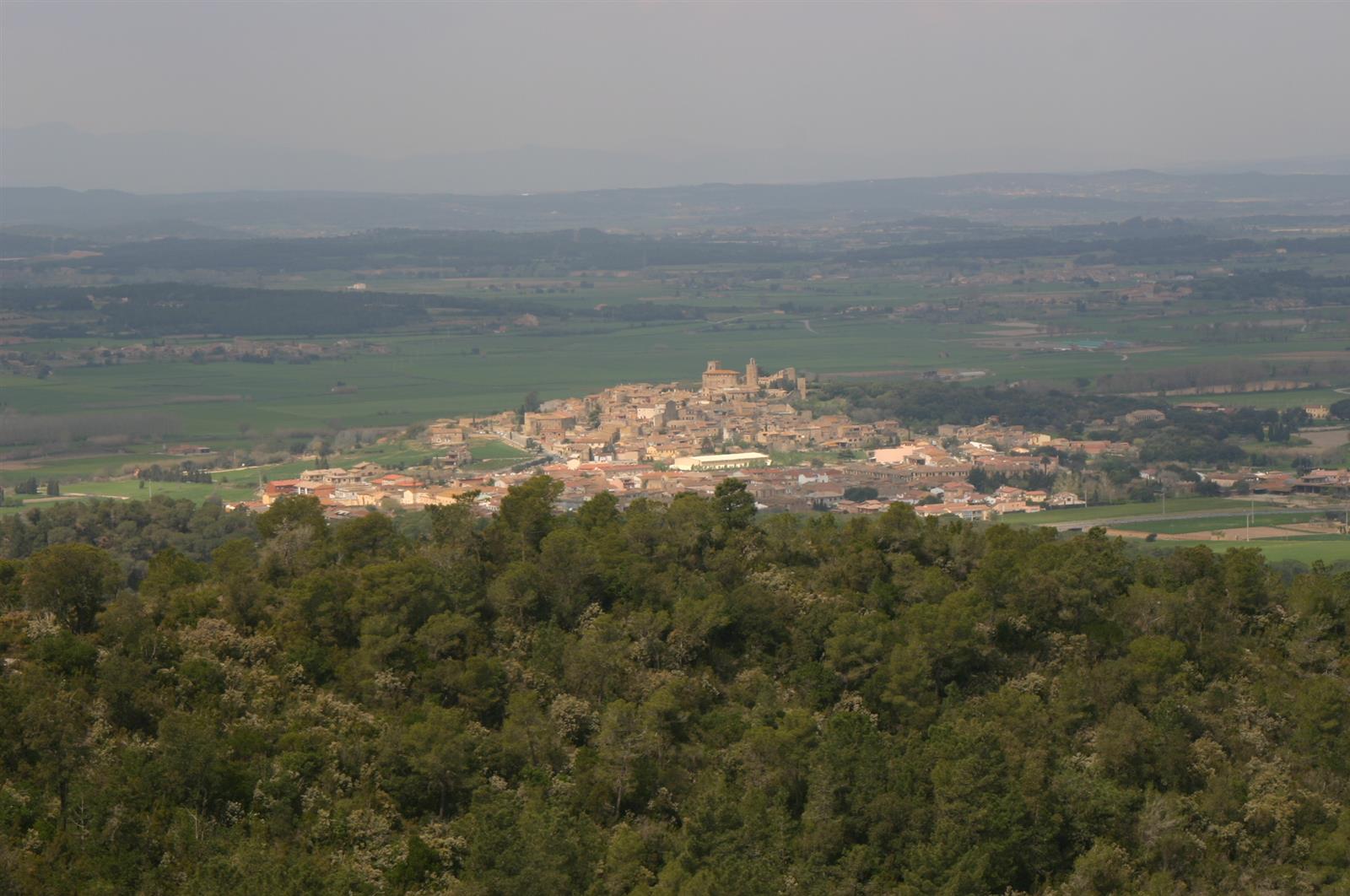 El pueblo de Pals visto desde el Quermany, con el casco histórico medieval entre campos del Empordà y el azul del mar al fondo