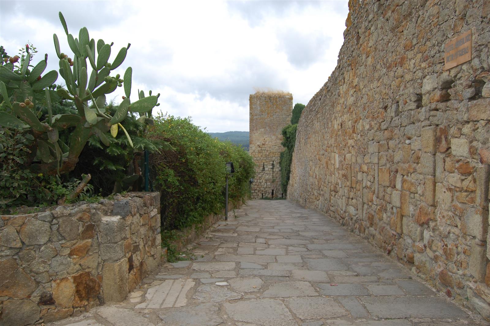 Murallas medievales de Pals con torres de piedra y cielo azul, Baix Empordà, Girona