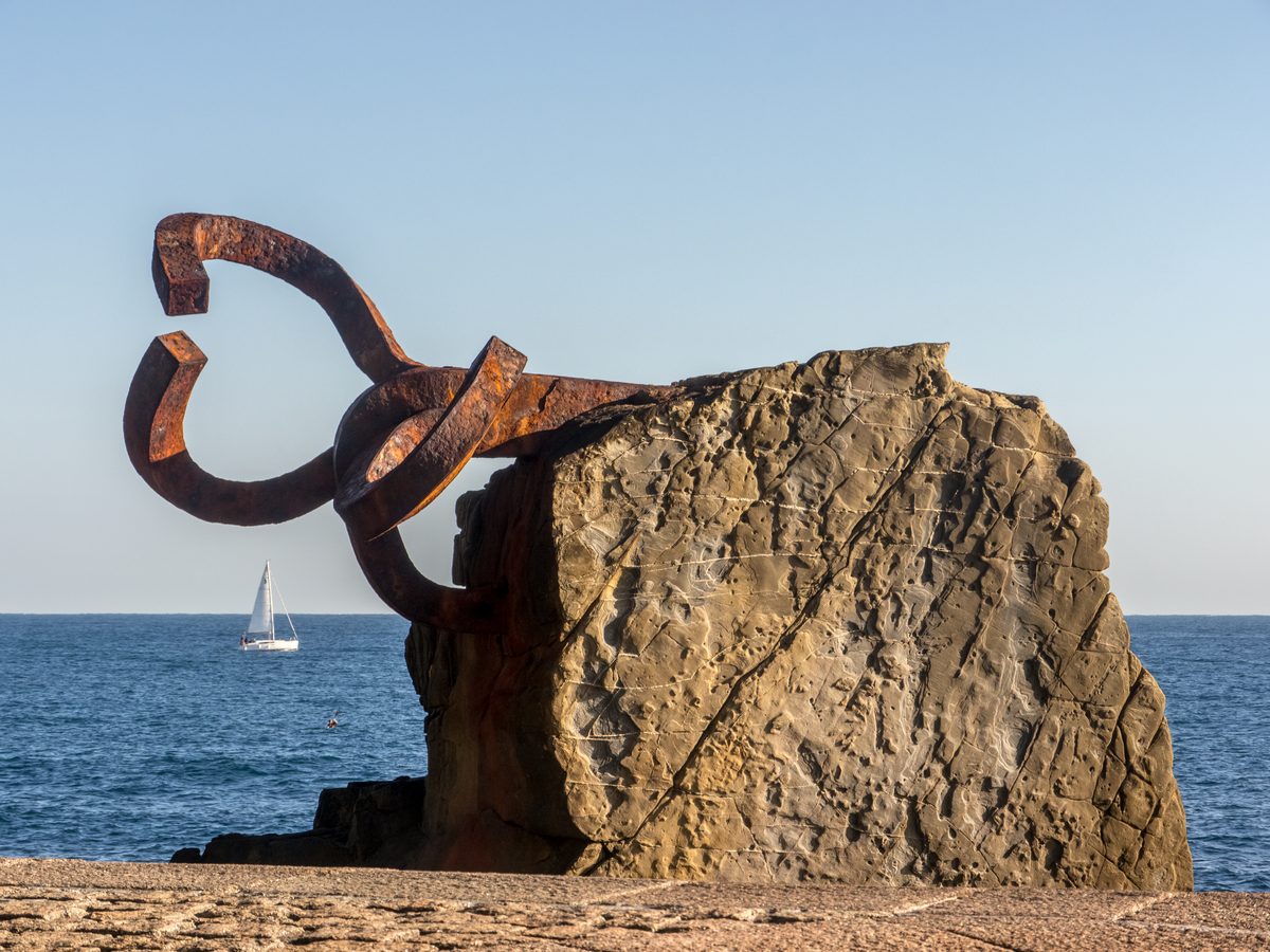 Escultura XV del Peine del Viento de Chillida en San Sebastián: garra de acero corten sobre las rocas de Ondarreta con el mar Cantábrico al fondo, imagen de calidad Wikimedia