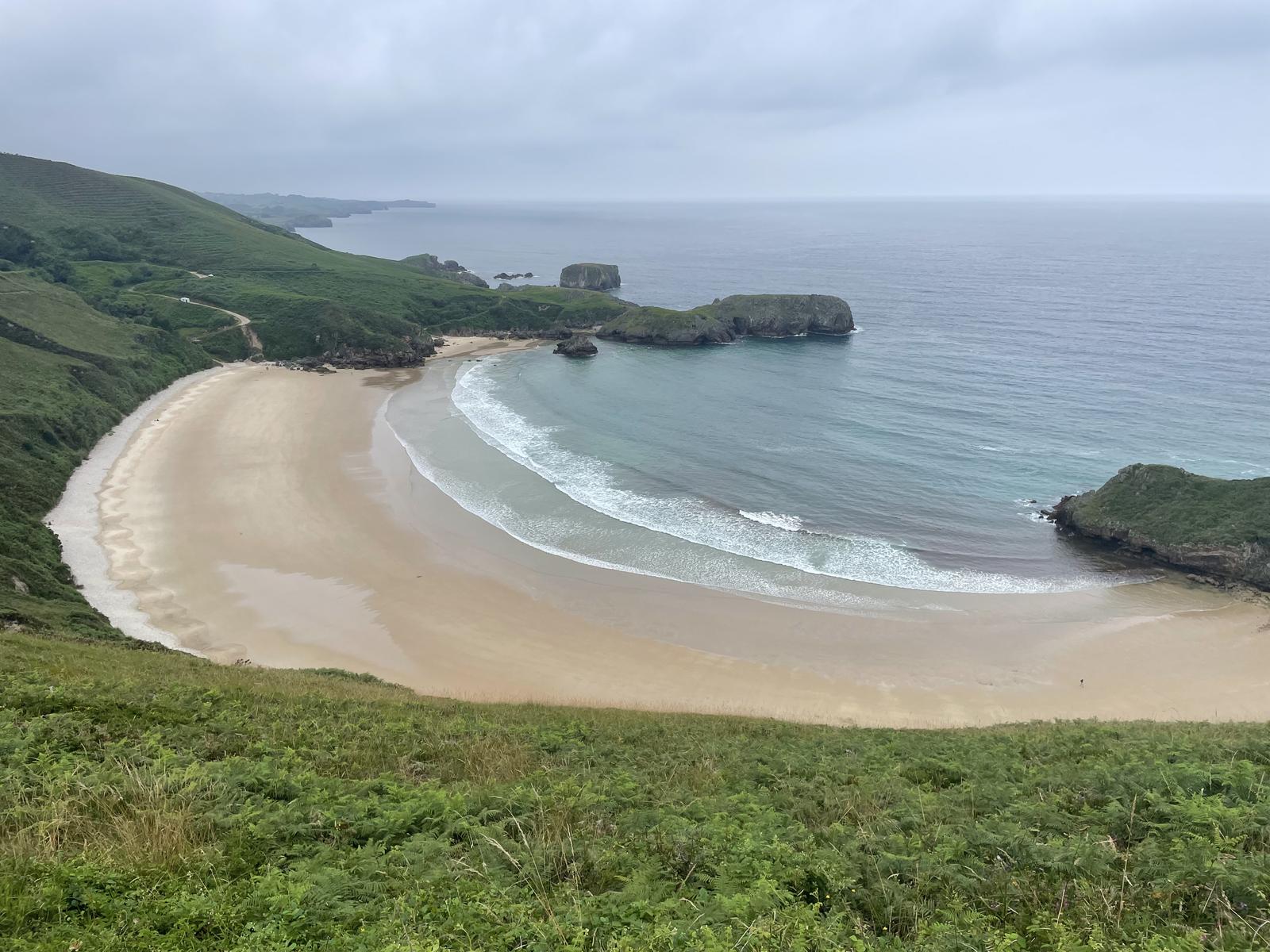 Vista de la Playa de Torimbia con el mar verde-azul del Cantábrico y las paredes rocosas laterales
